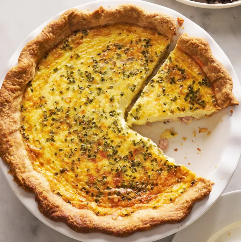 A homemade quiche on a white plate
