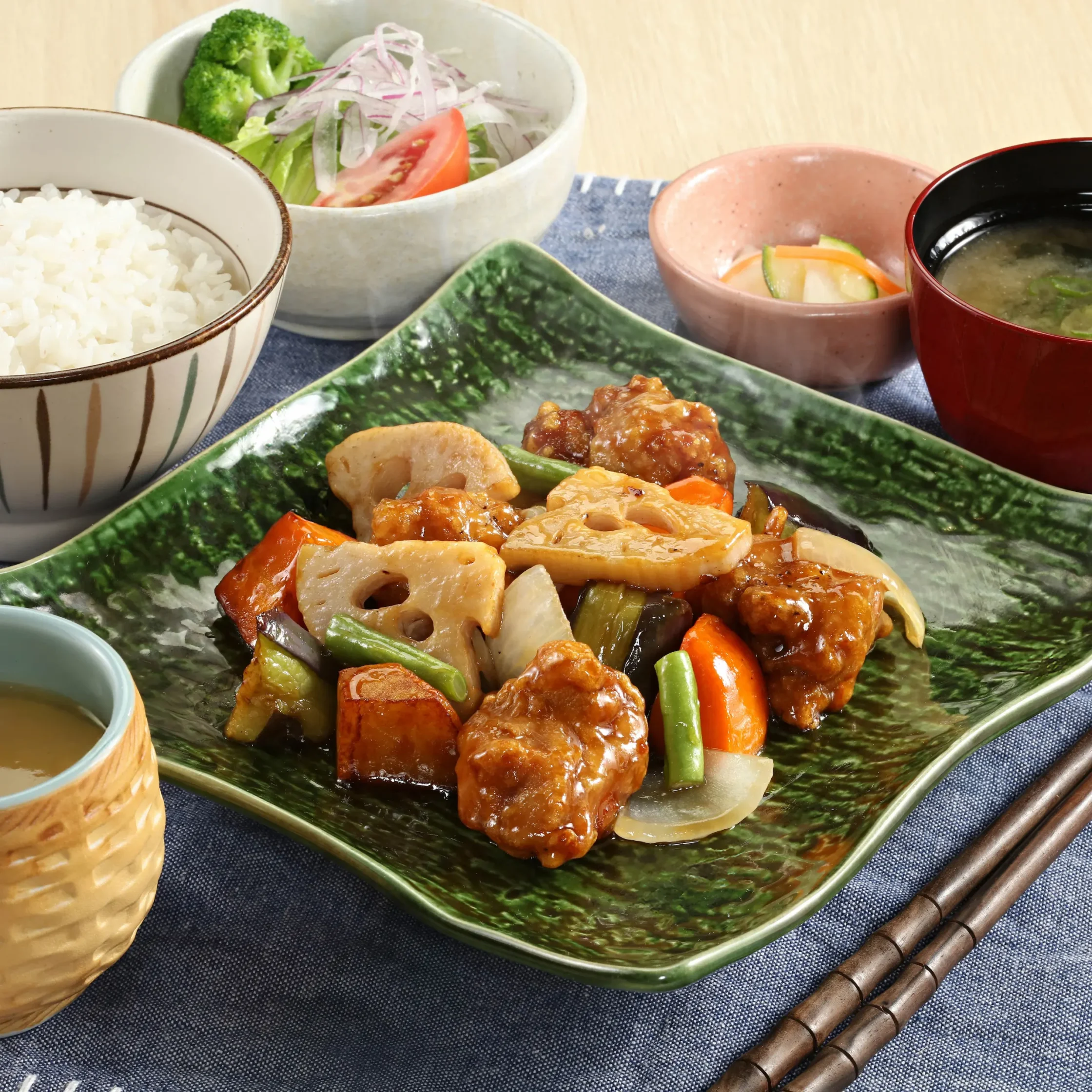 Ootoya’s Chicken Kurozu featuring crispy fried chicken pieces glazed in black vinegar sauce with vegetables, served with steamed rice, miso soup, salad, pickles, and tea.