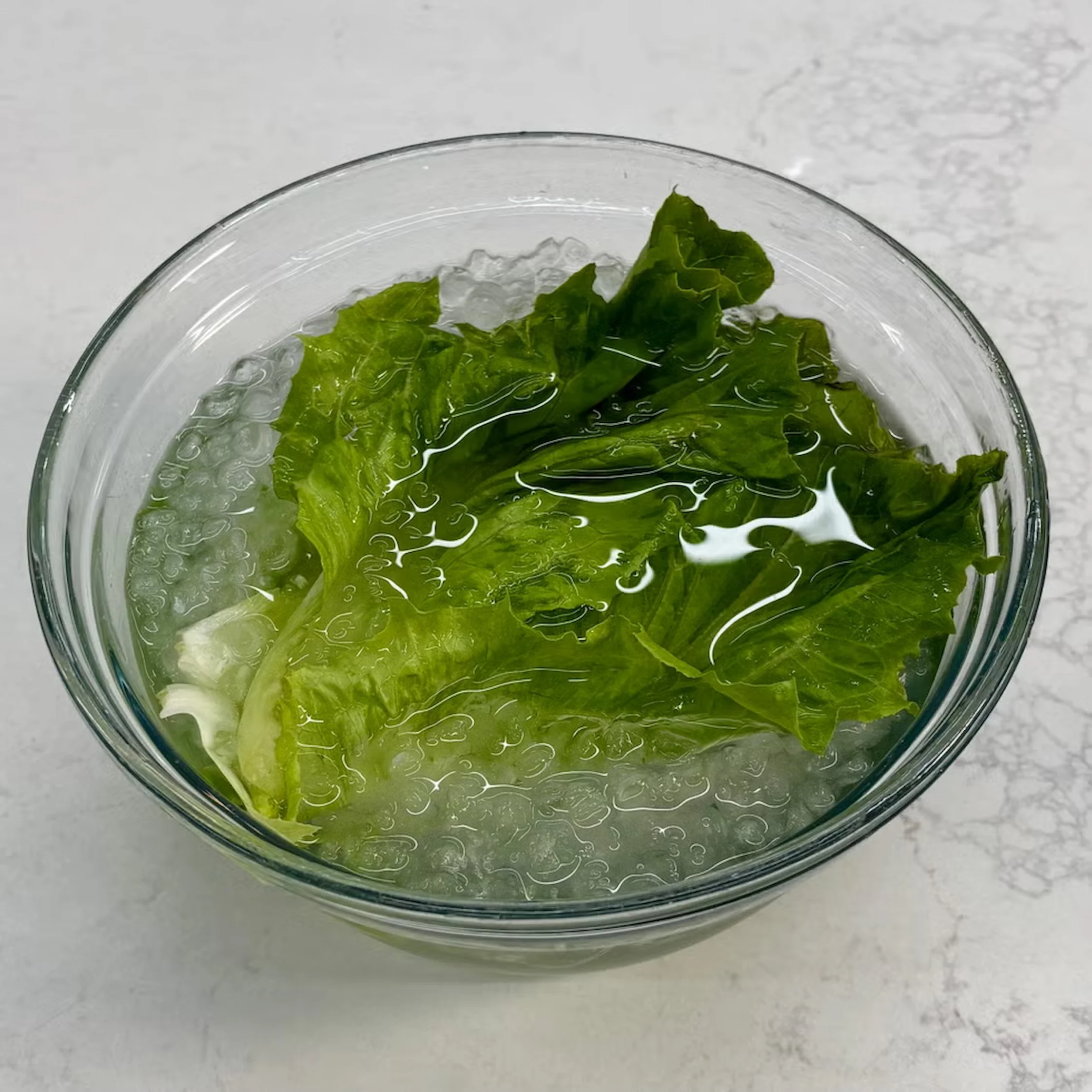 Leafy greens in ice after hot water treatment