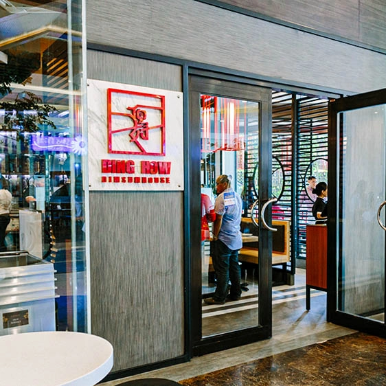 Entrance of Ding How Dimsumhouse restaurant with signage displayed beside the glass doors.