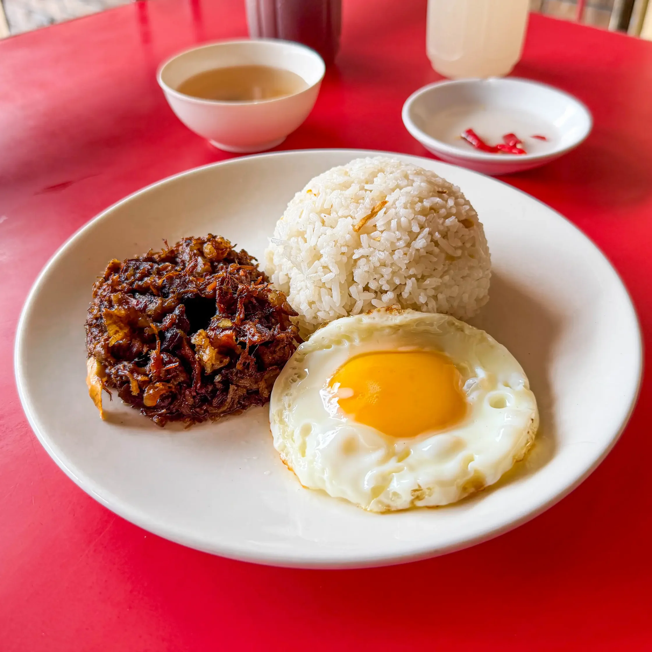 Maty’s tapsilog meal featuring tapa, garlic fried rice, and a sunny-side-up egg served on a white plate.