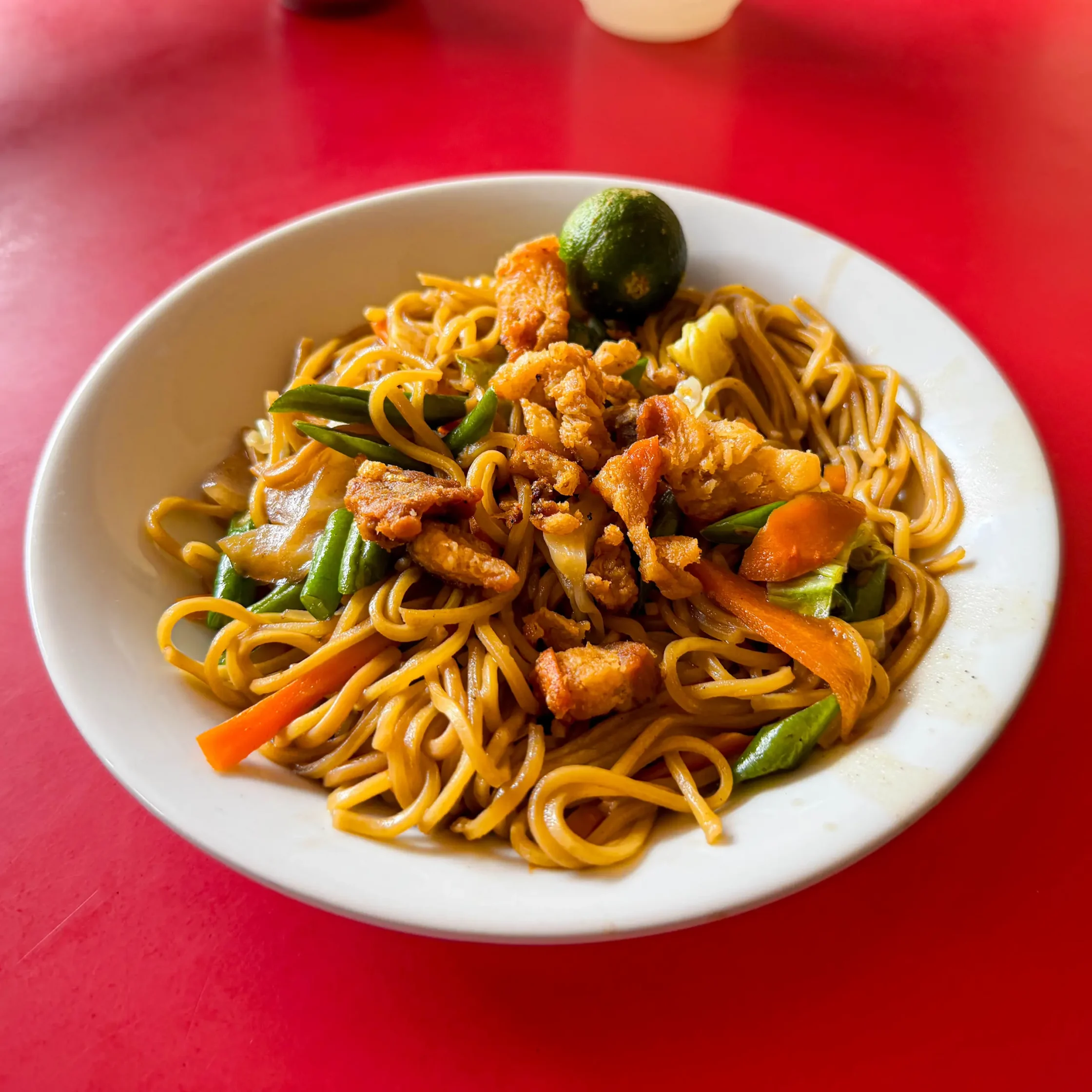 Maty’s pancit canton stir-fried noodles topped with pork pieces and mixed vegetables, served with calamansi on the side.