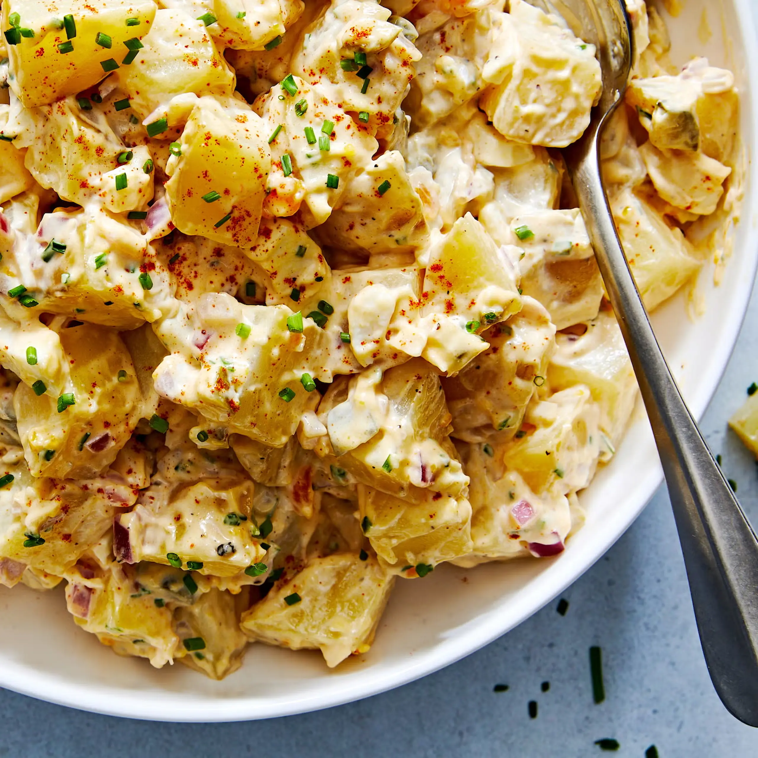 A large glass bowl of creamy potato salad