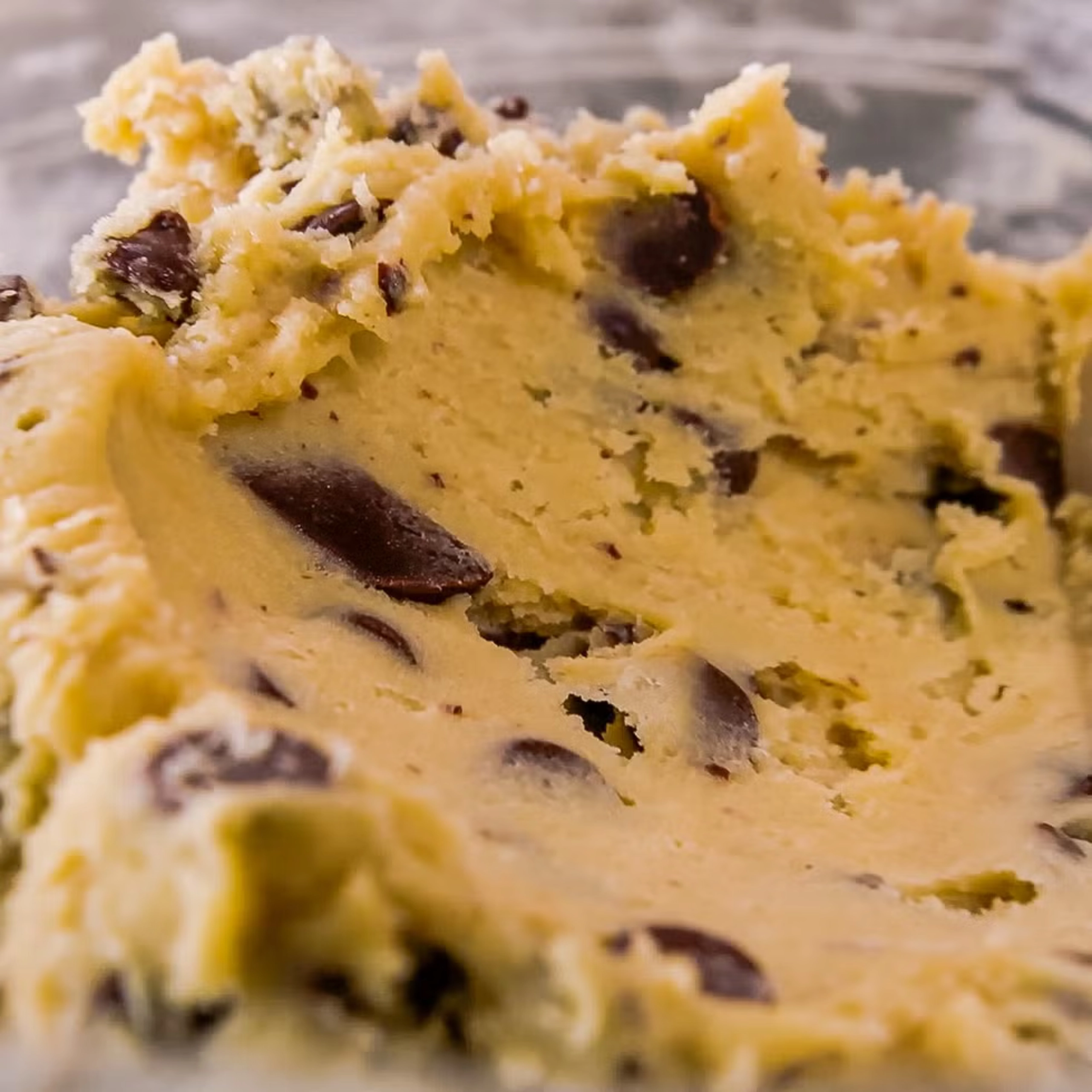 Close-up of a chocolate chip cookie with gooey, crumbly texture and dark chips scattered throughout