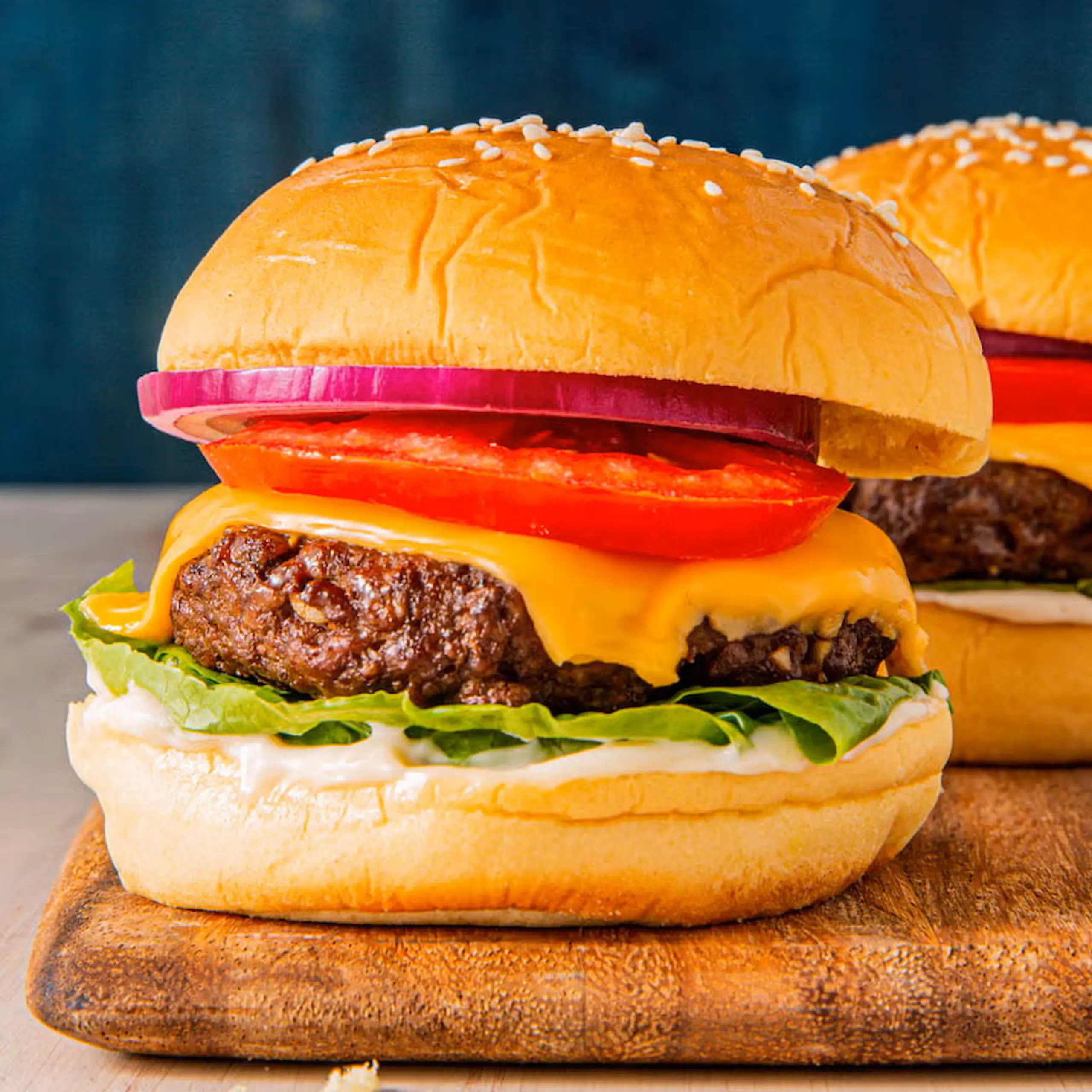 cheeseburger on wooden chopping board