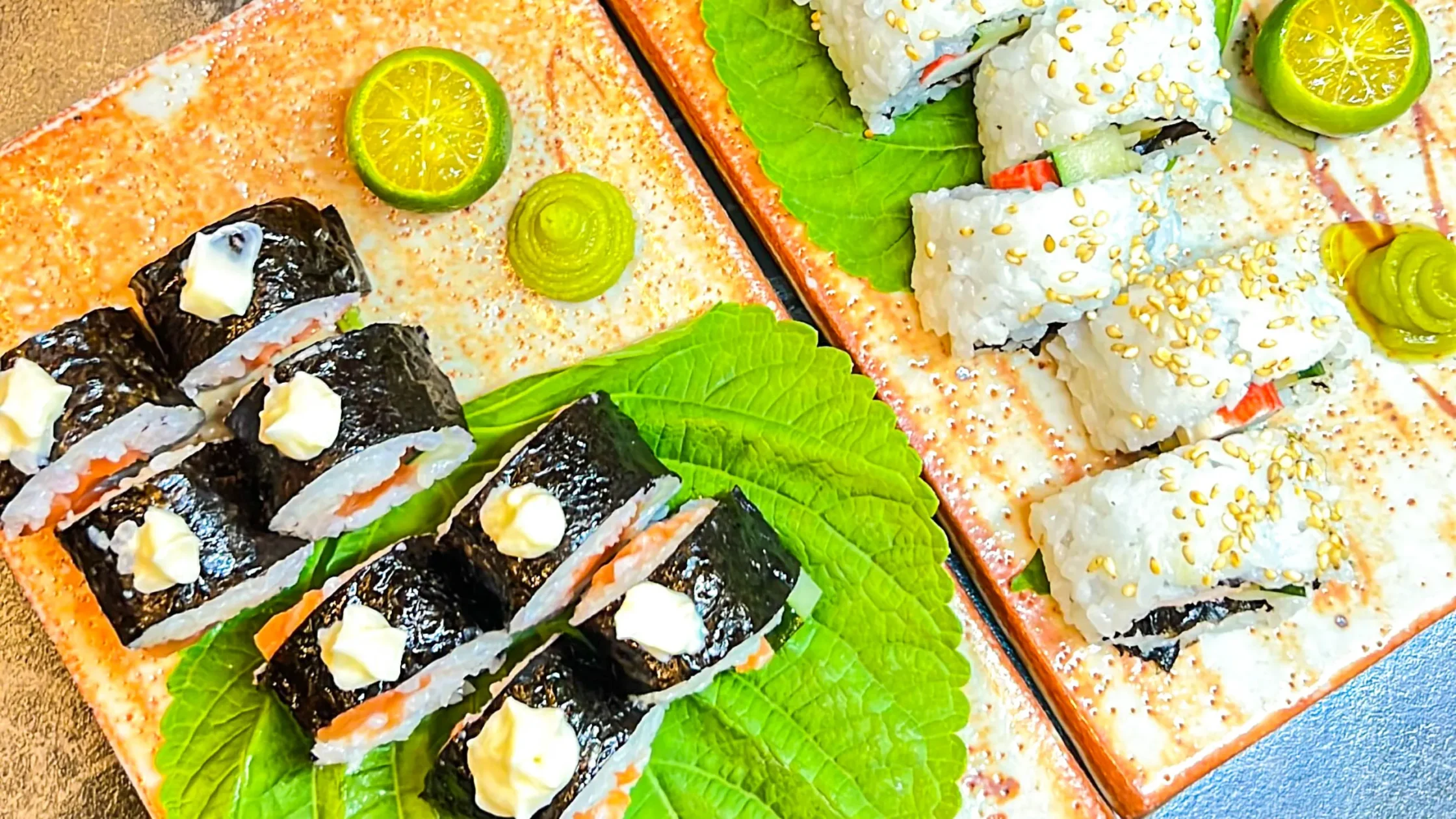 Assorted sushi rolls with sesame seeds, seaweed wraps, fresh vegetables, and citrus garnish served on elegant plates by a private chef.