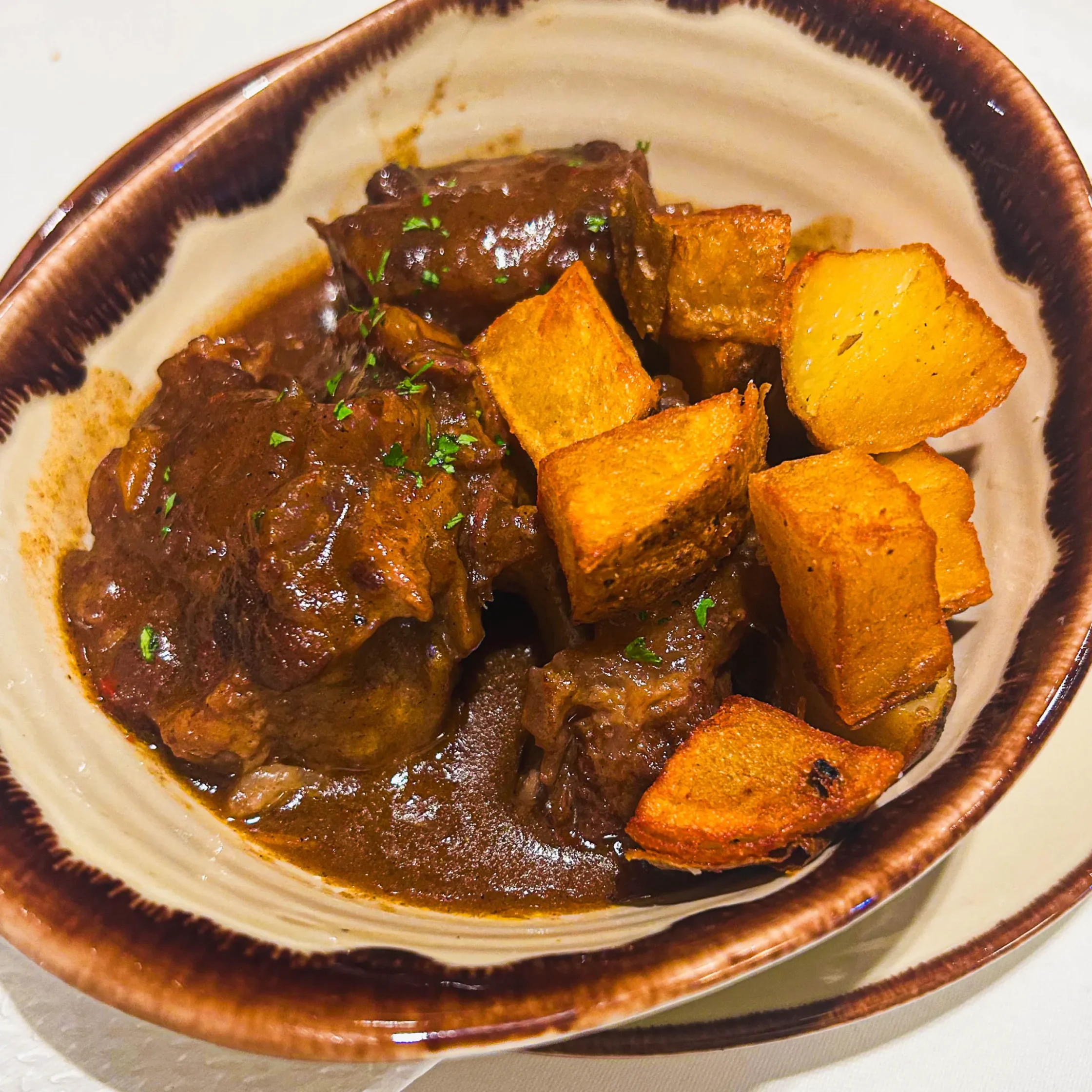 Patatas bravas at Asador de Aranda Manila with crispy roasted potatoes and rich Spanish-style beef stew sauce