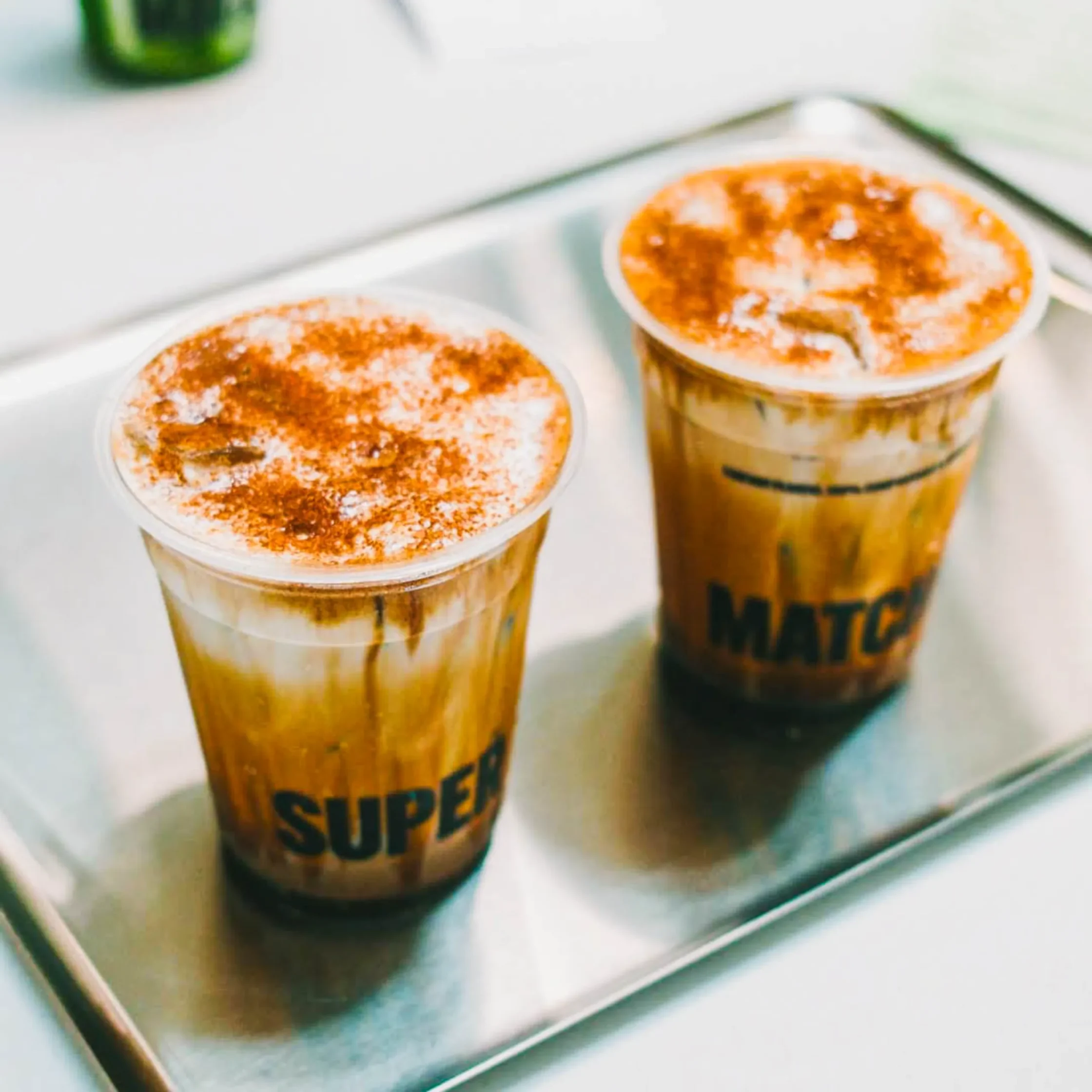 Creamy iced bori latte drinks topped with foam and cinnamon powder served on a metal tray at Super Matcha café in the Philippines.