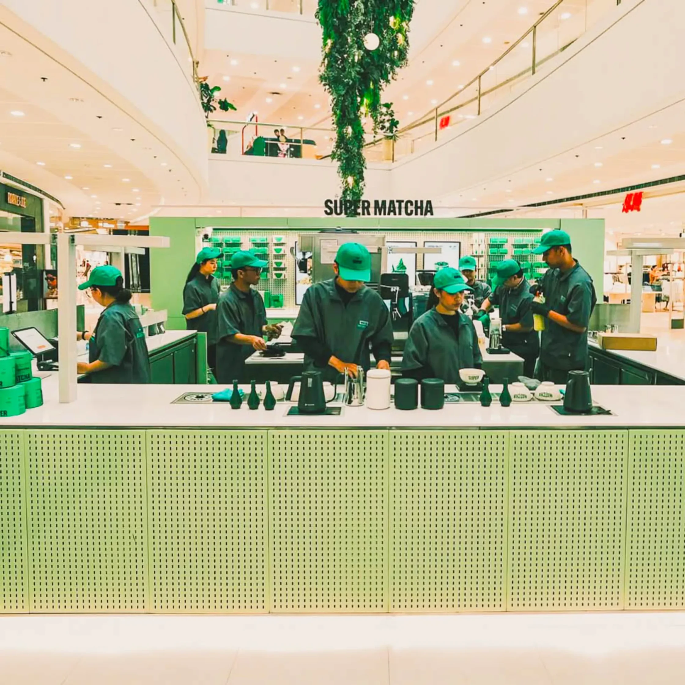 Super Matcha kiosk branch inside SM Megamall featuring baristas preparing matcha drinks in a modern minimalist café setup.