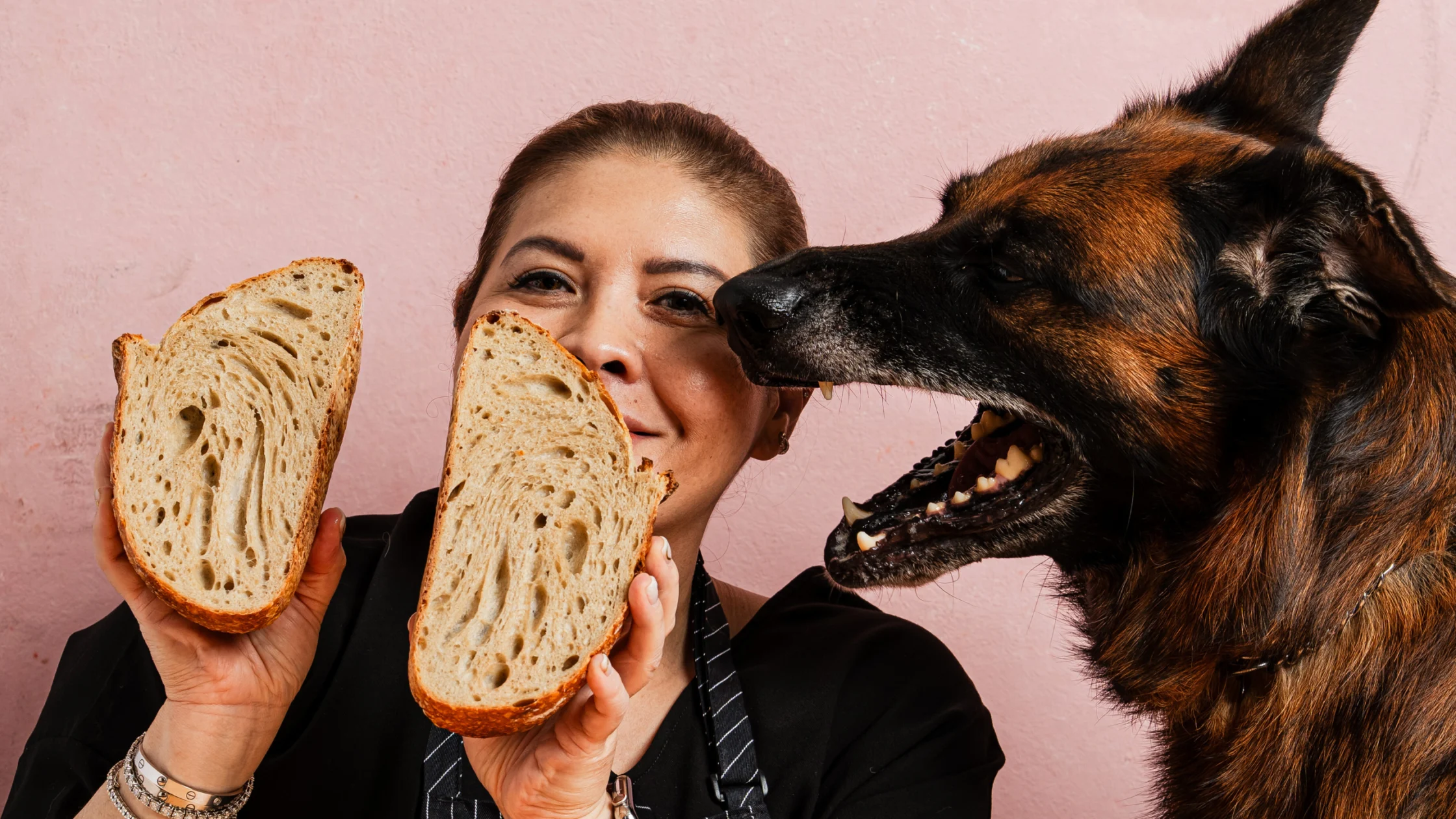 Woman holding sliced sourdough next to a dog