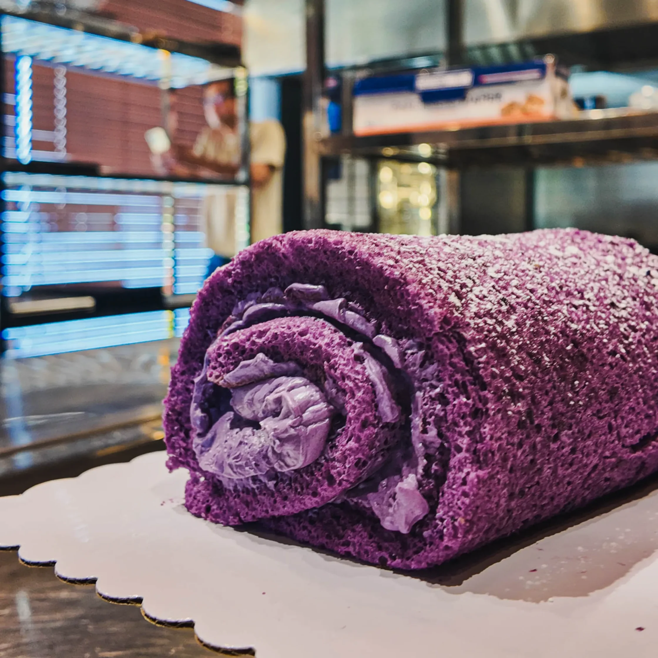 Close-up of a freshly baked ube cake roll with rich purple cream filling at 50&Co Bakery, featuring Filipino-inspired dessert flavors and premium handcrafted pastry presentation.