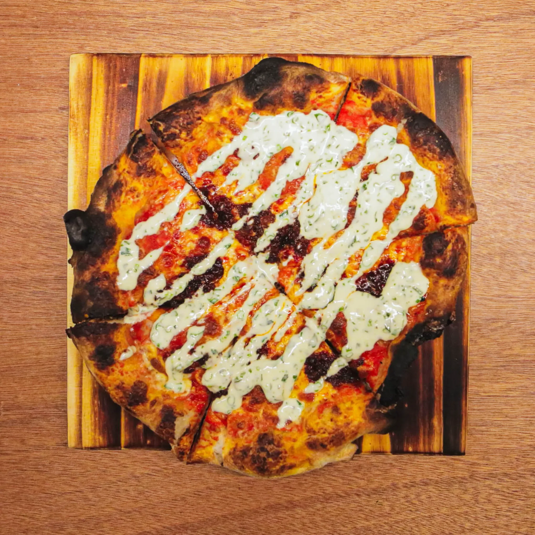 Overhead shot of Rectoroni pepperoni pizza with creamy ranch sauce, melted cheese, and blistered crust served on a wooden board at Cutie Pie Pizza Makati.