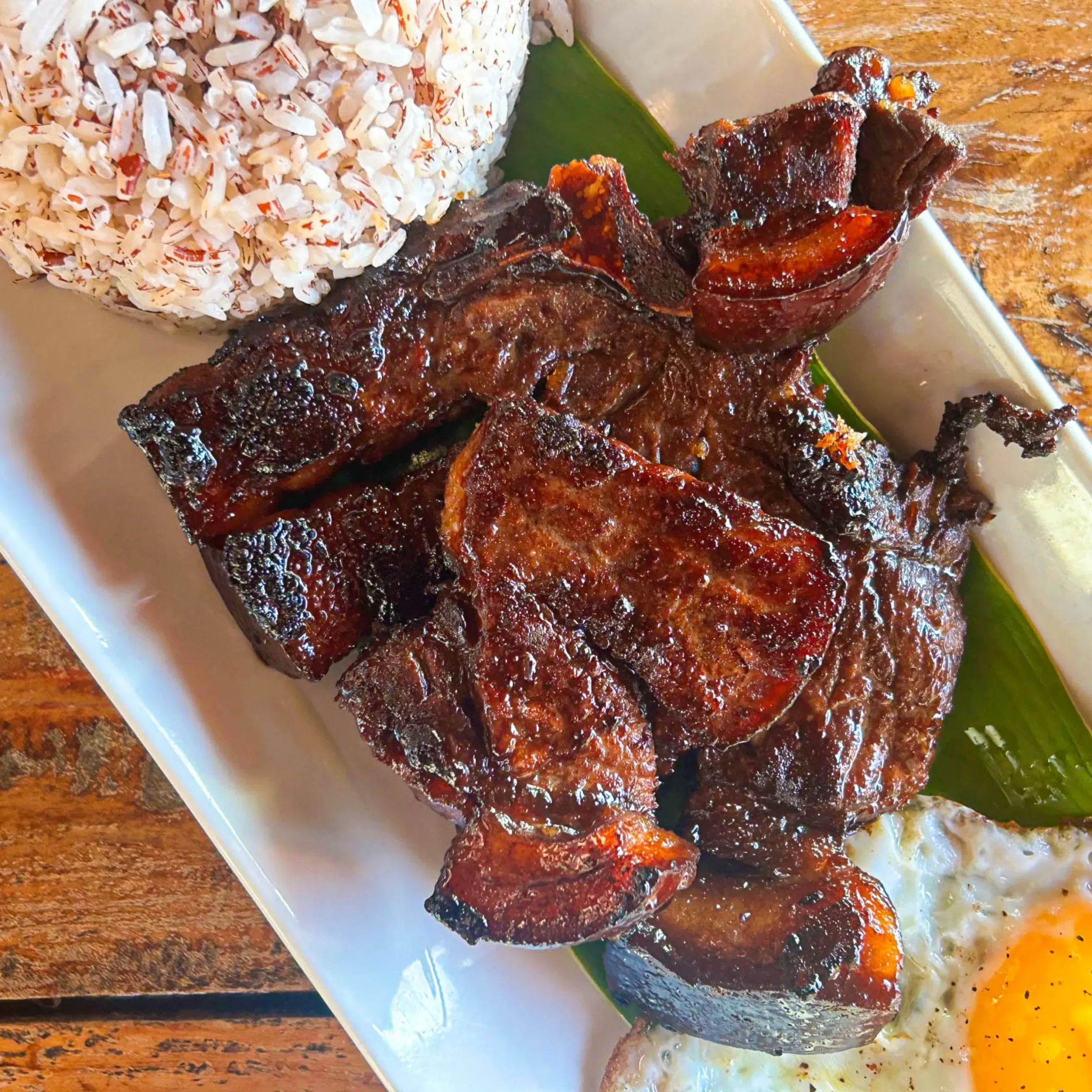 Grilled Hanoi-style pork chop meal from Guerrera Restaurant in Camiguin with rice, fried egg, and caramelized savory pork.