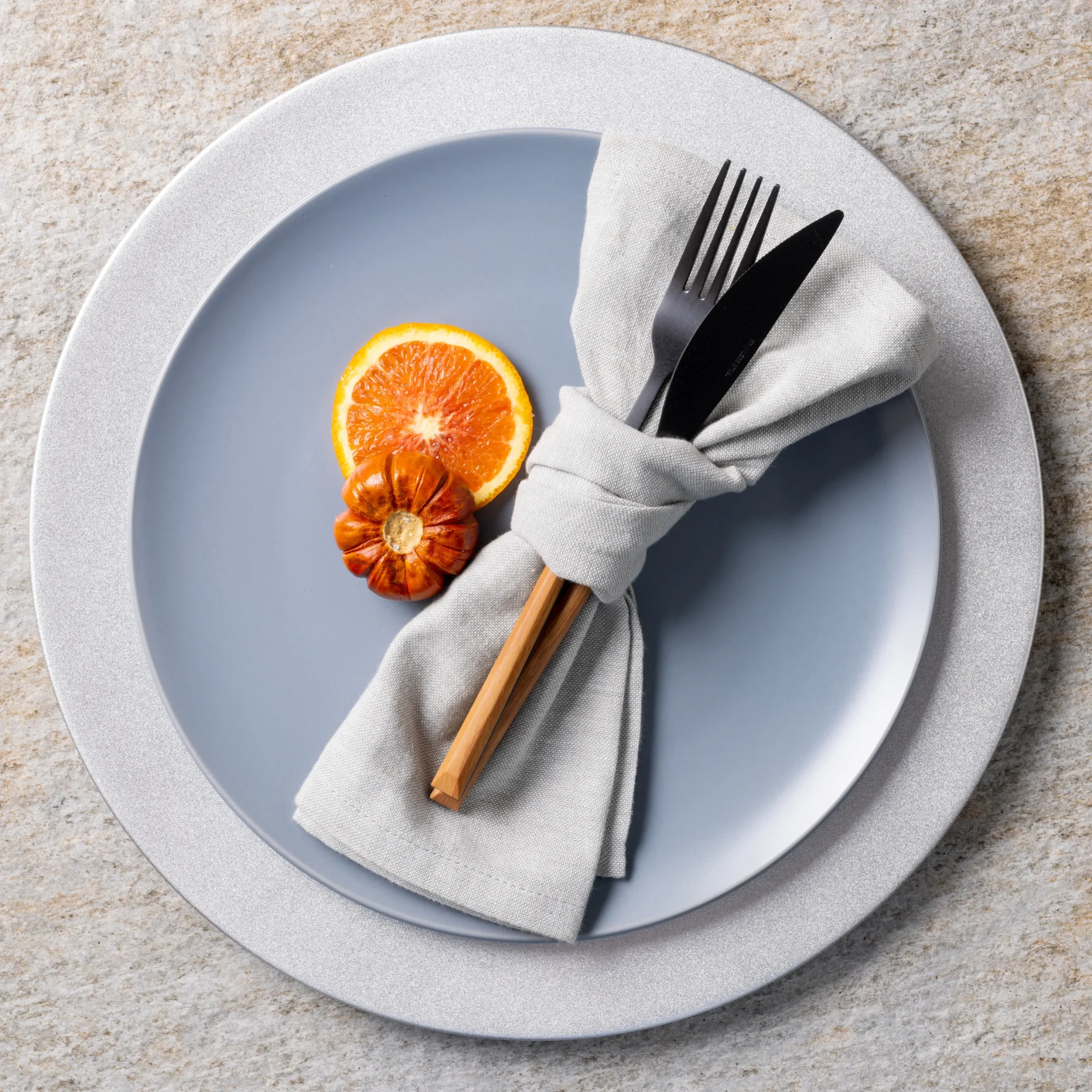 Textured blue dessert plate featuring three gourmet dessert spheres with fruit sauce garnishes and edible flowers, presented on a vibrant green and pink tabletop for fine dining service.