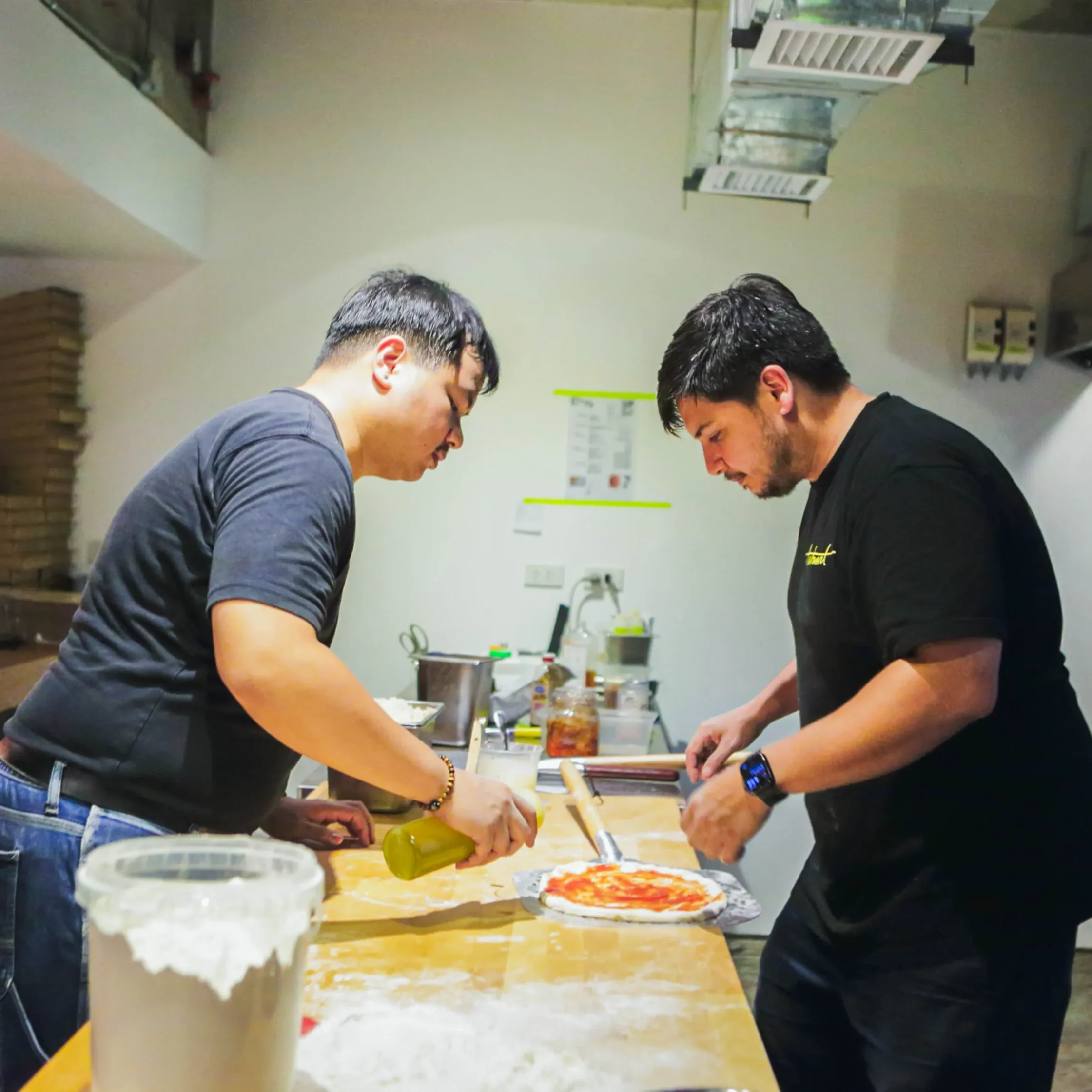 Pizza chefs preparing artisan pizzas in the open kitchen at Cutie Pie Pizza in Makati City