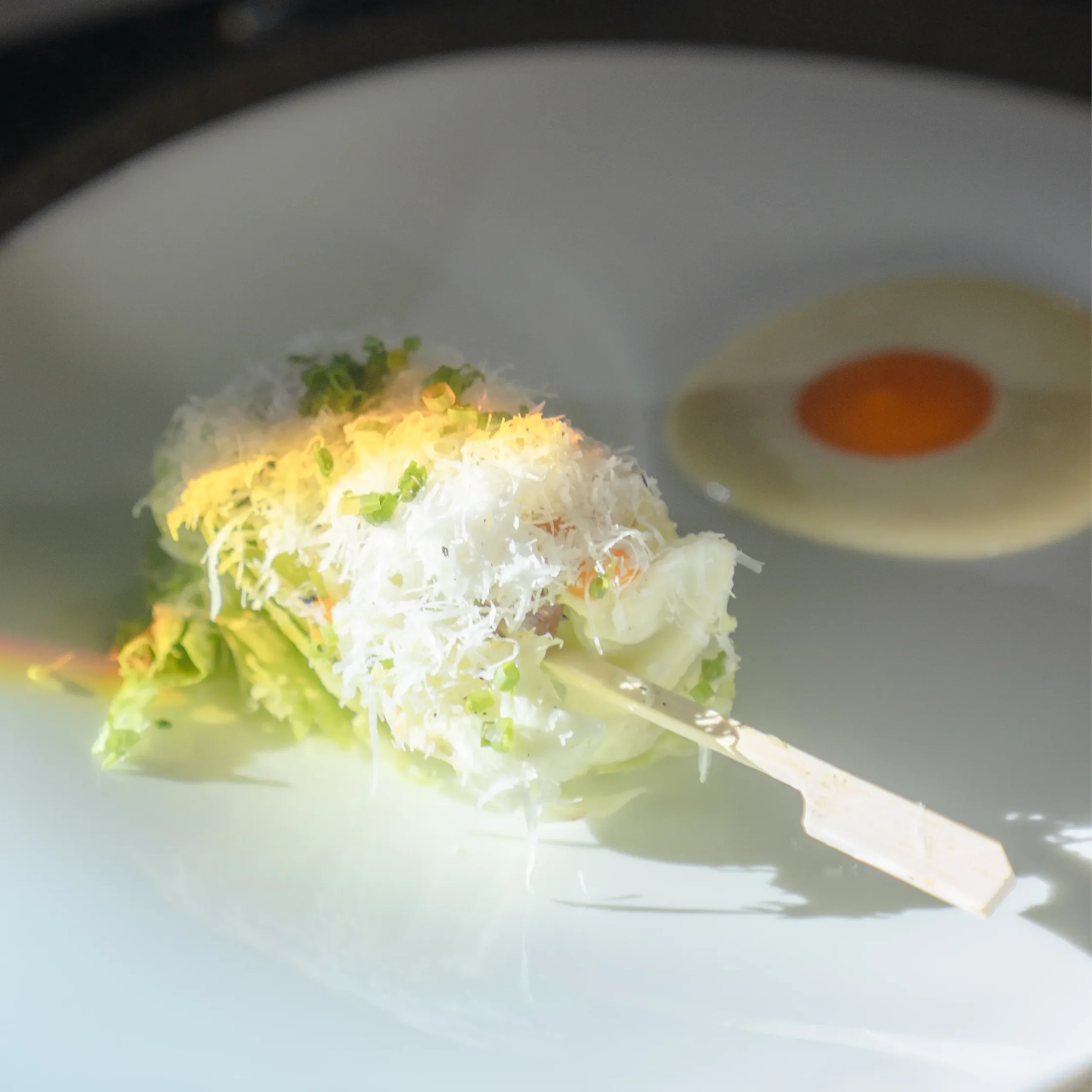 Chef Frances Tariga's Tadhana menu at the Mega Ball elevates Caesar Salad with crisp greens, shaved cheese, and refined presentation.