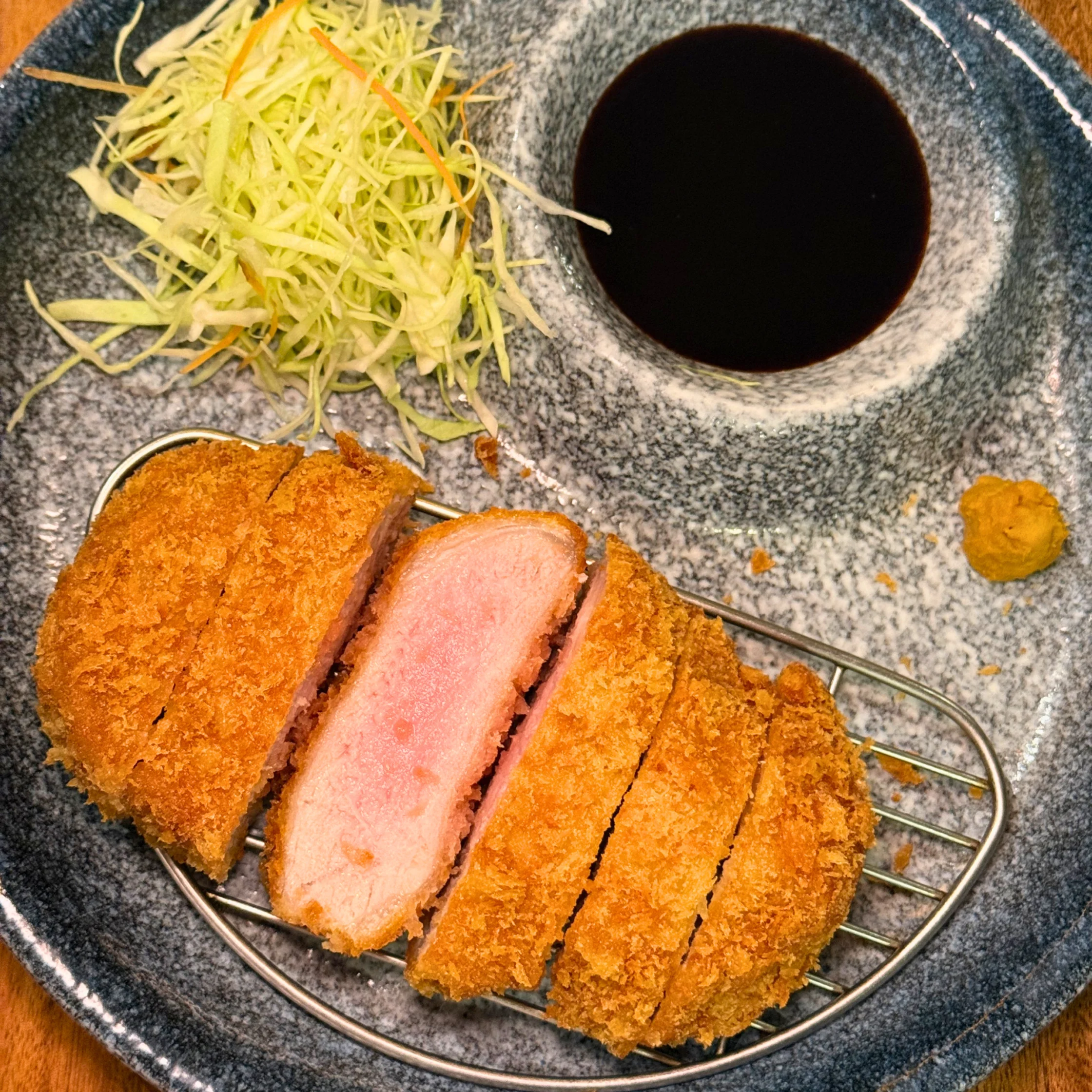 Assorted tonkatsu cuts served with rice, soup, and finely shredded cabbage, featuring premium Kagoshima Kurobuta pork prepared in the Horiichi style.