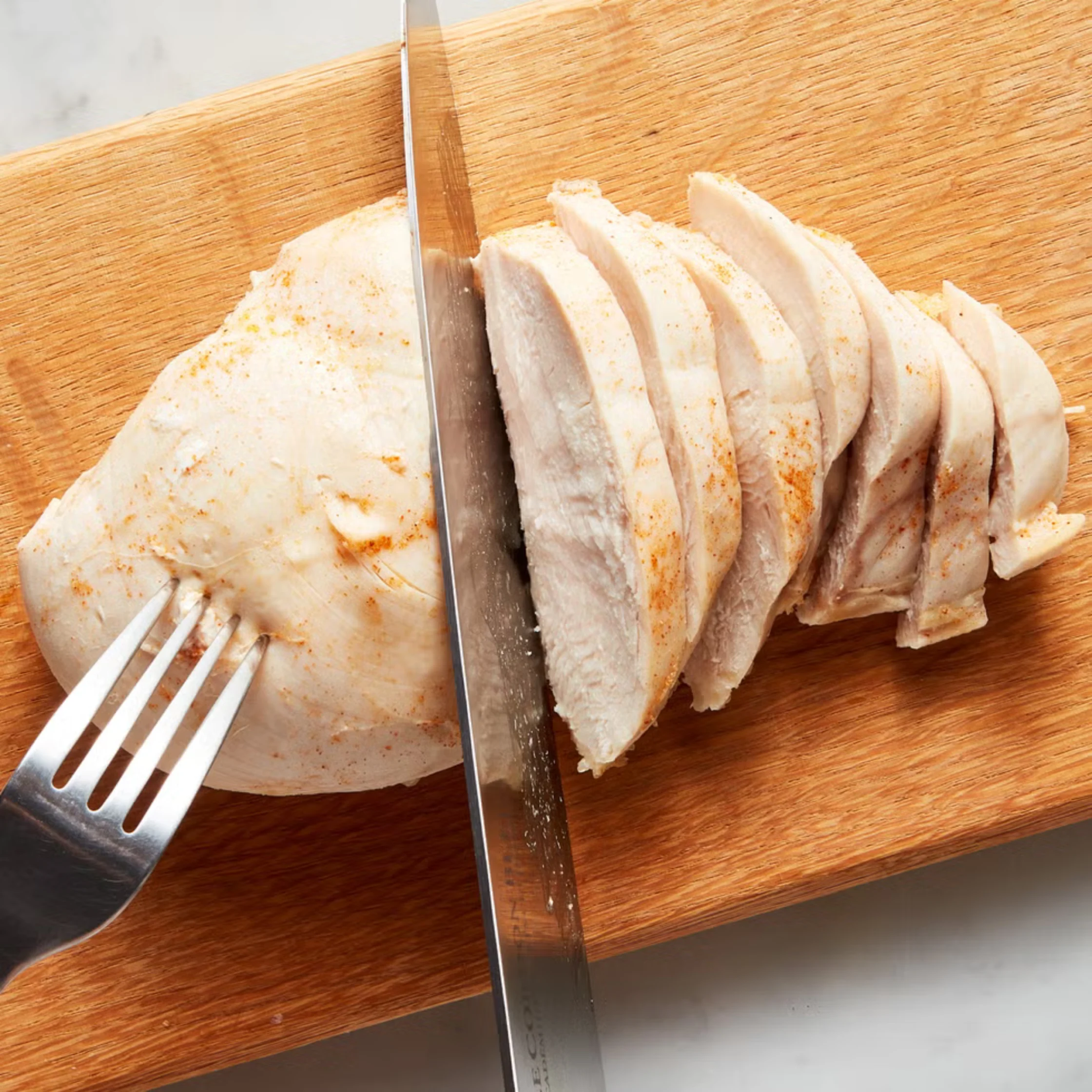 chicken breast being cut into cubes