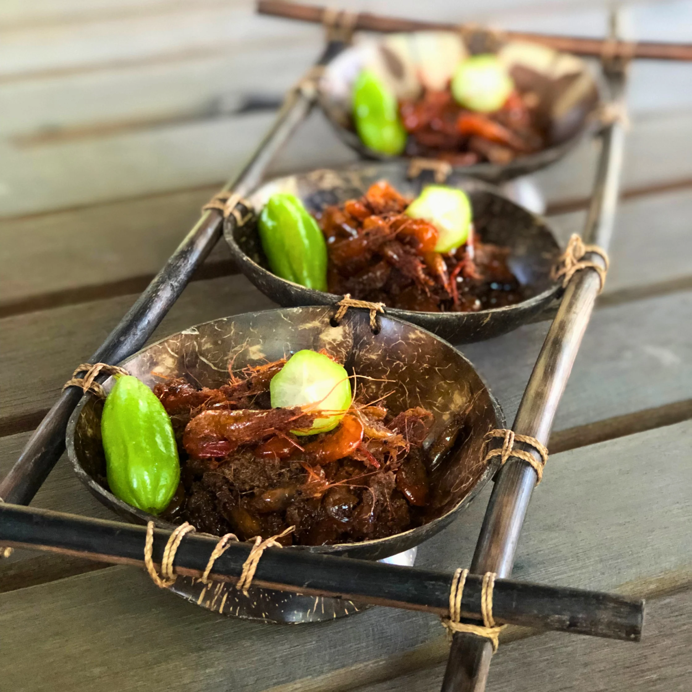 Ginataang Yapyap served in coconut-shell bowls, featuring freshwater shrimp slowly cooked in coconut cream and kamias until rich and glossy.