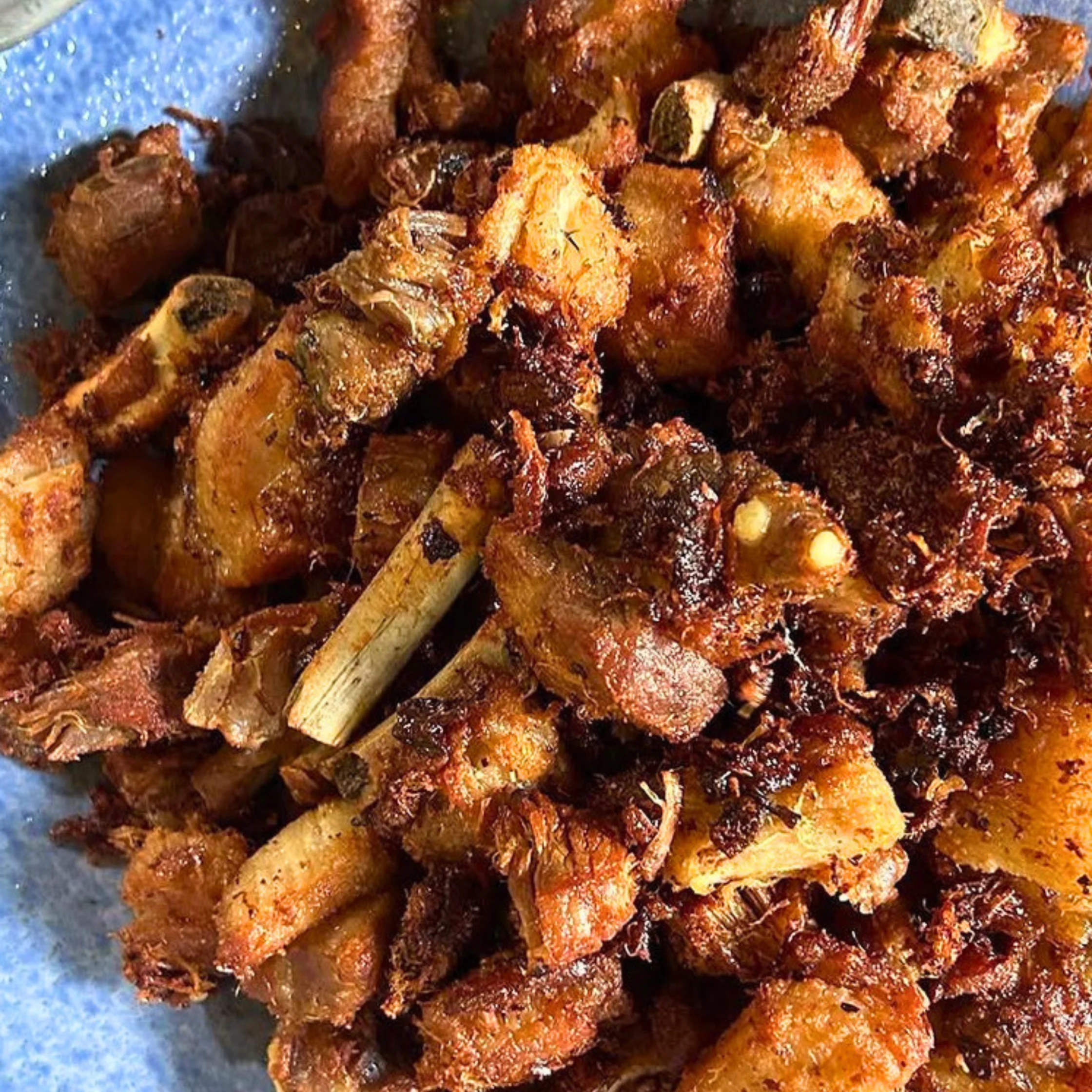 Crispy Pata bits or pritong laman-loob at balat ng baboy. The pork skin, fat, and meat have been deep-fried until crisp, a style common in Pampanga where various pork cuts are fried and served as pulutan or viand.
