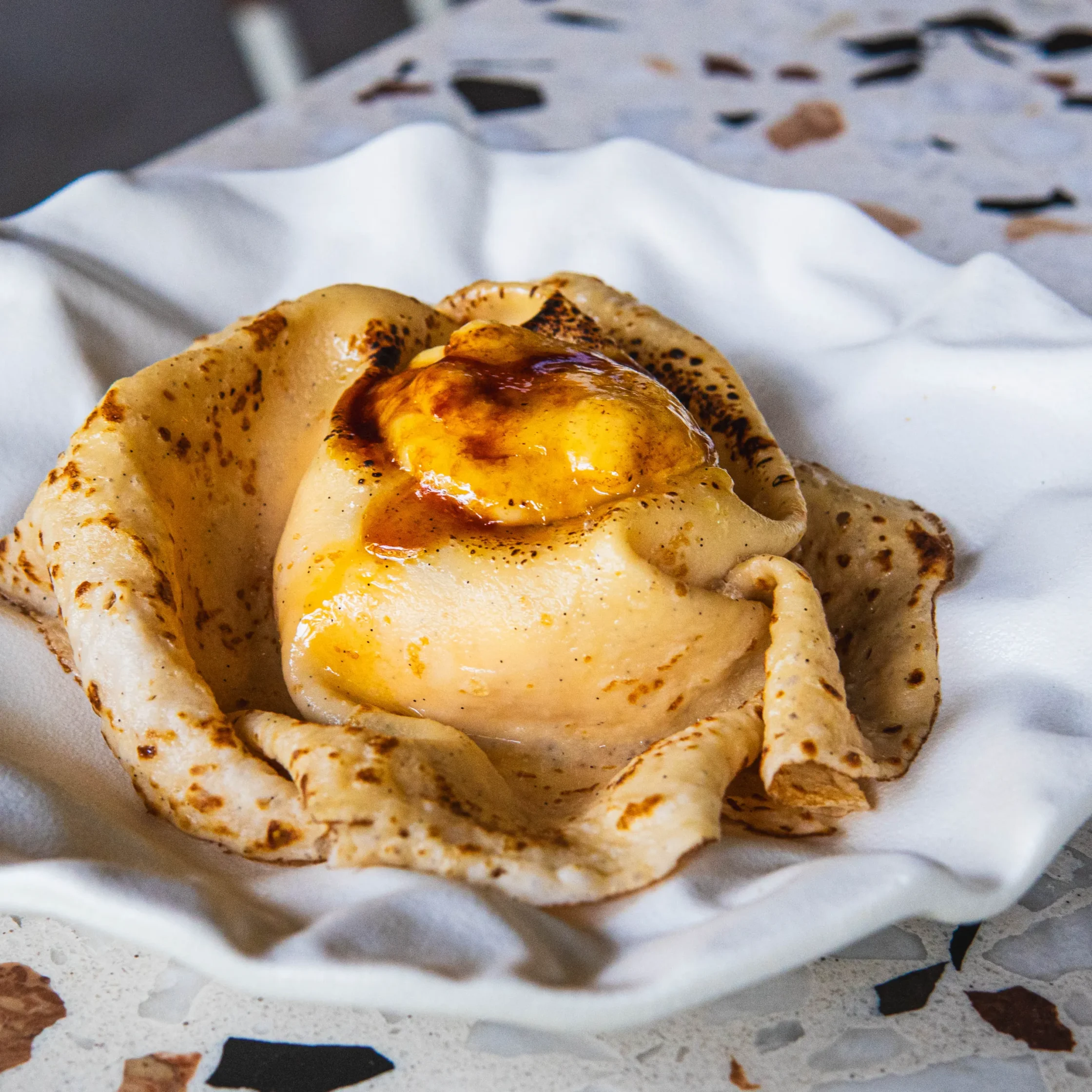 Matcha raspberry crêpe brûlée with caramelized topping and a scoop of ice cream wrapped in a delicate crêpe.