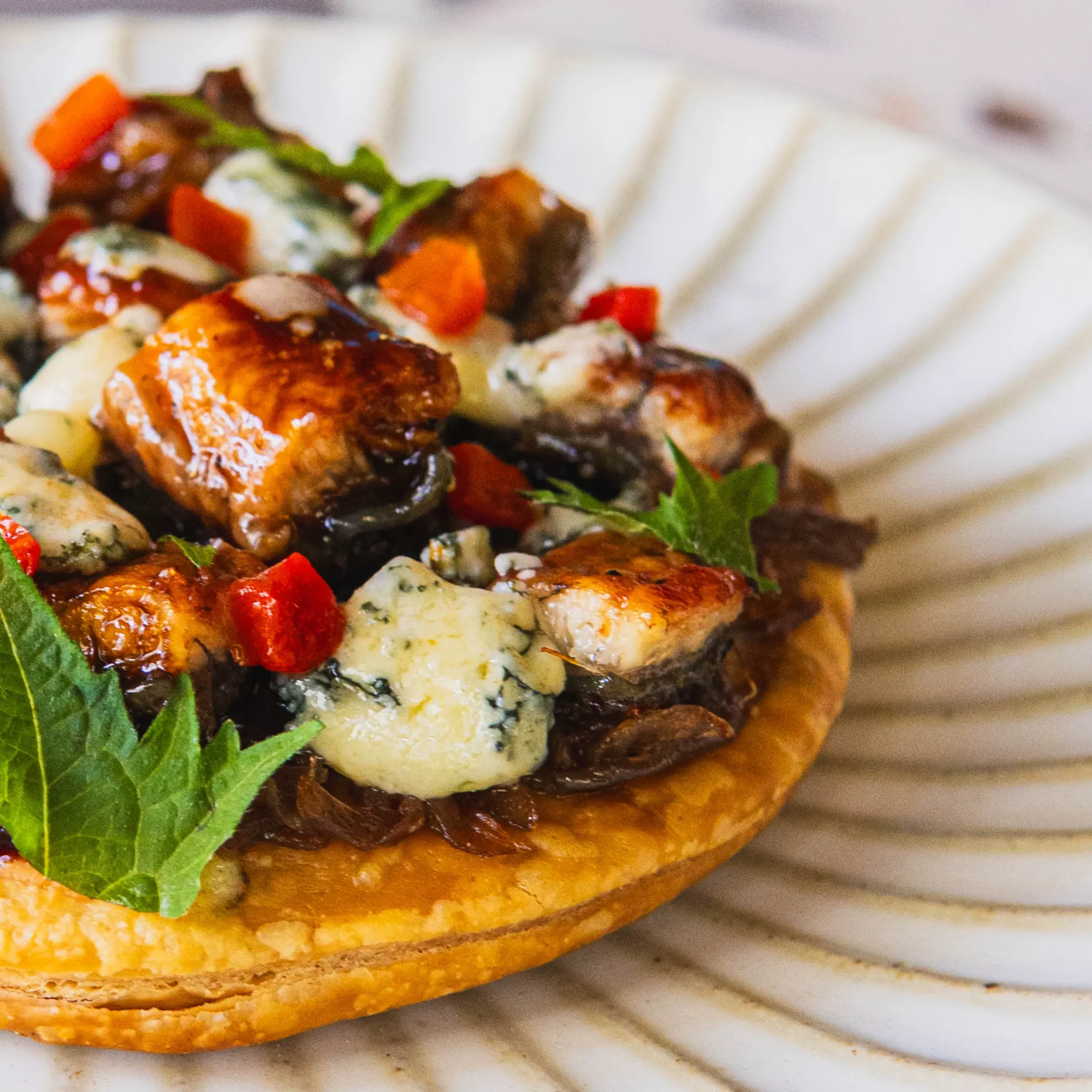 Crisp tarte fine topped with glazed eel, caramelized onions, blue cheese, herbs, and diced red peppers.