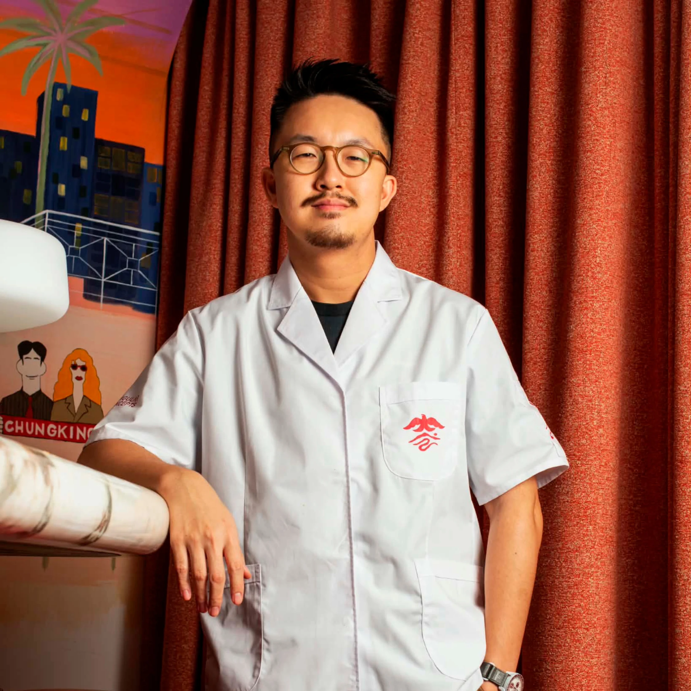 Kinsman co-founder Gavin Yeung stands inside the bar’s warmly lit interior, representing the Hong Kong cocktail salon’s culture-driven approach to hospitality and collaboration.