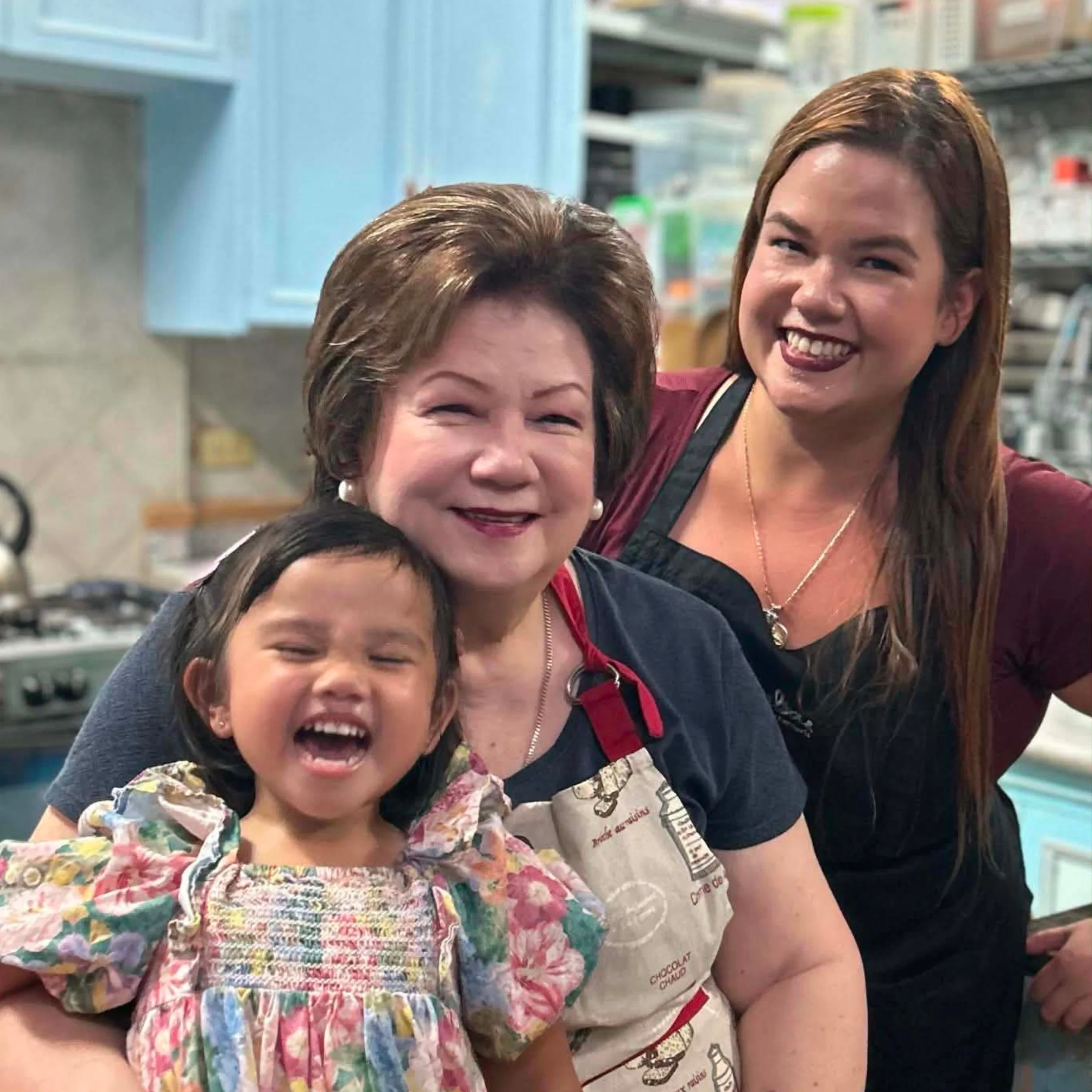 Family photo featuring Tina Legarda, her mom Bettina Legarda, and a young child together in a kitchen.