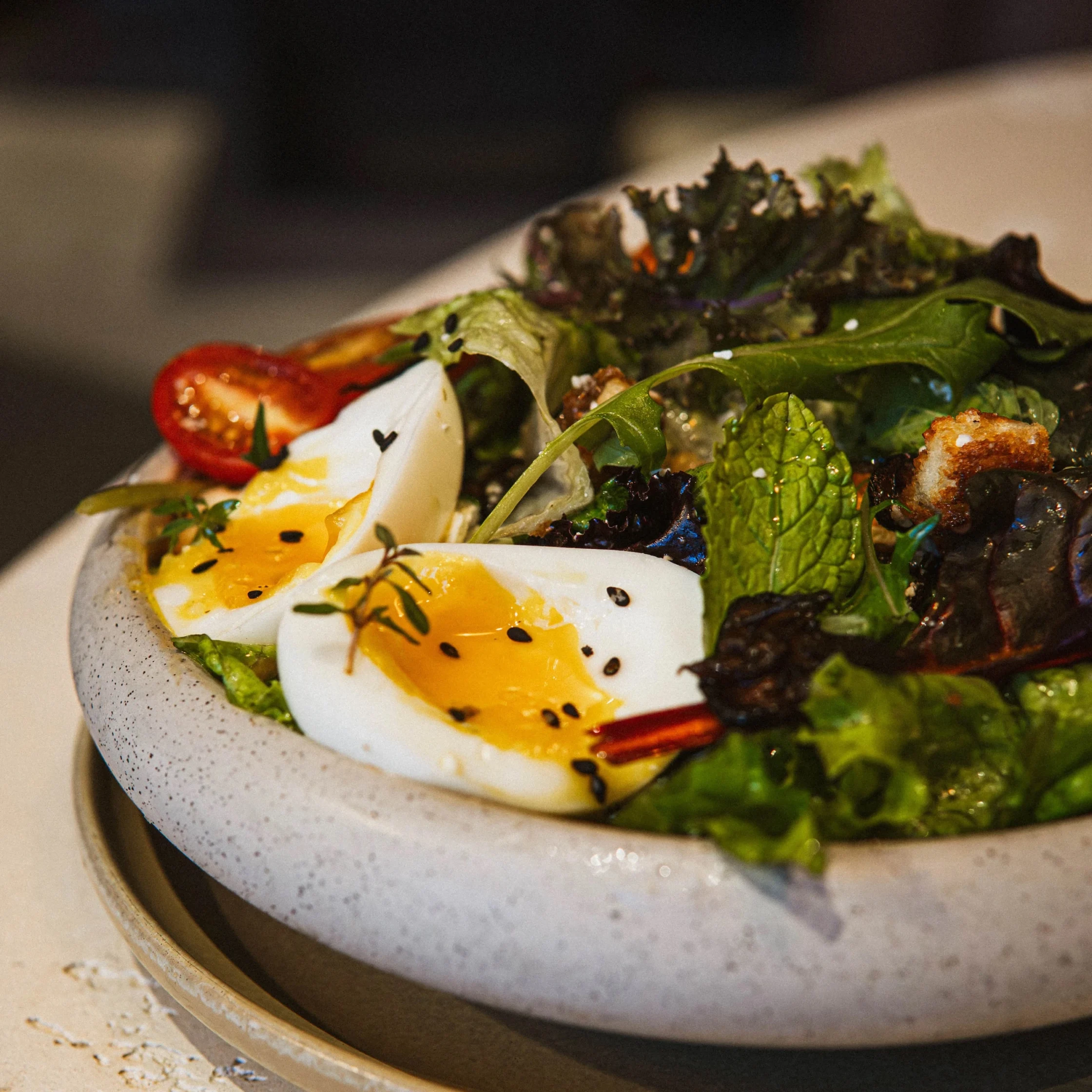 Greens salad and runny egg on a plate