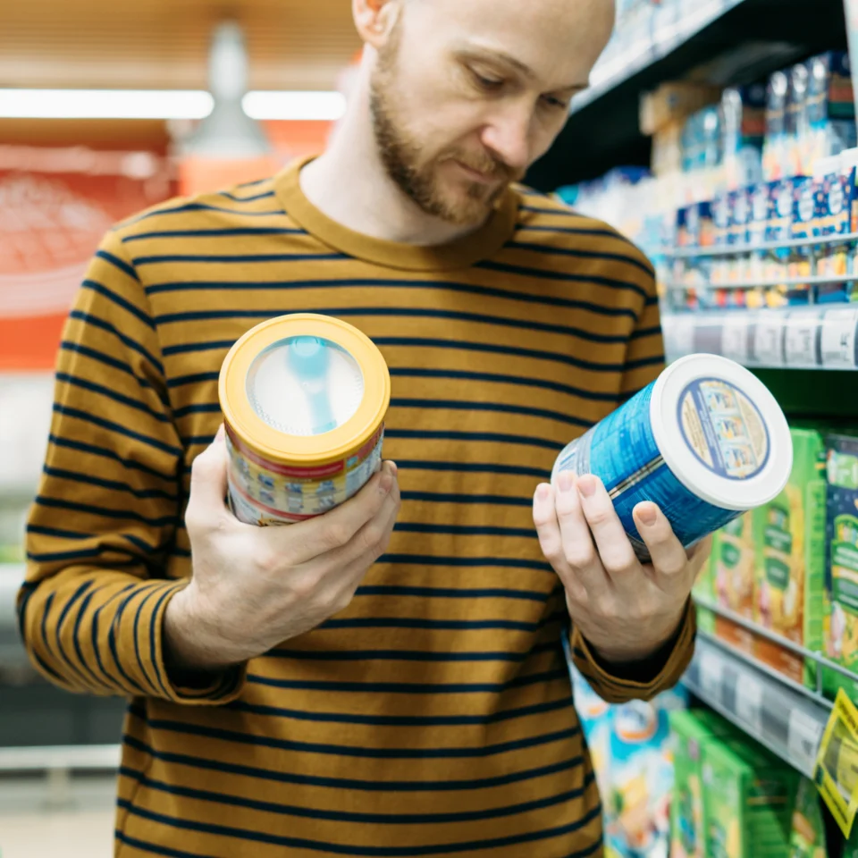 man checking nutrition labels in grocery store