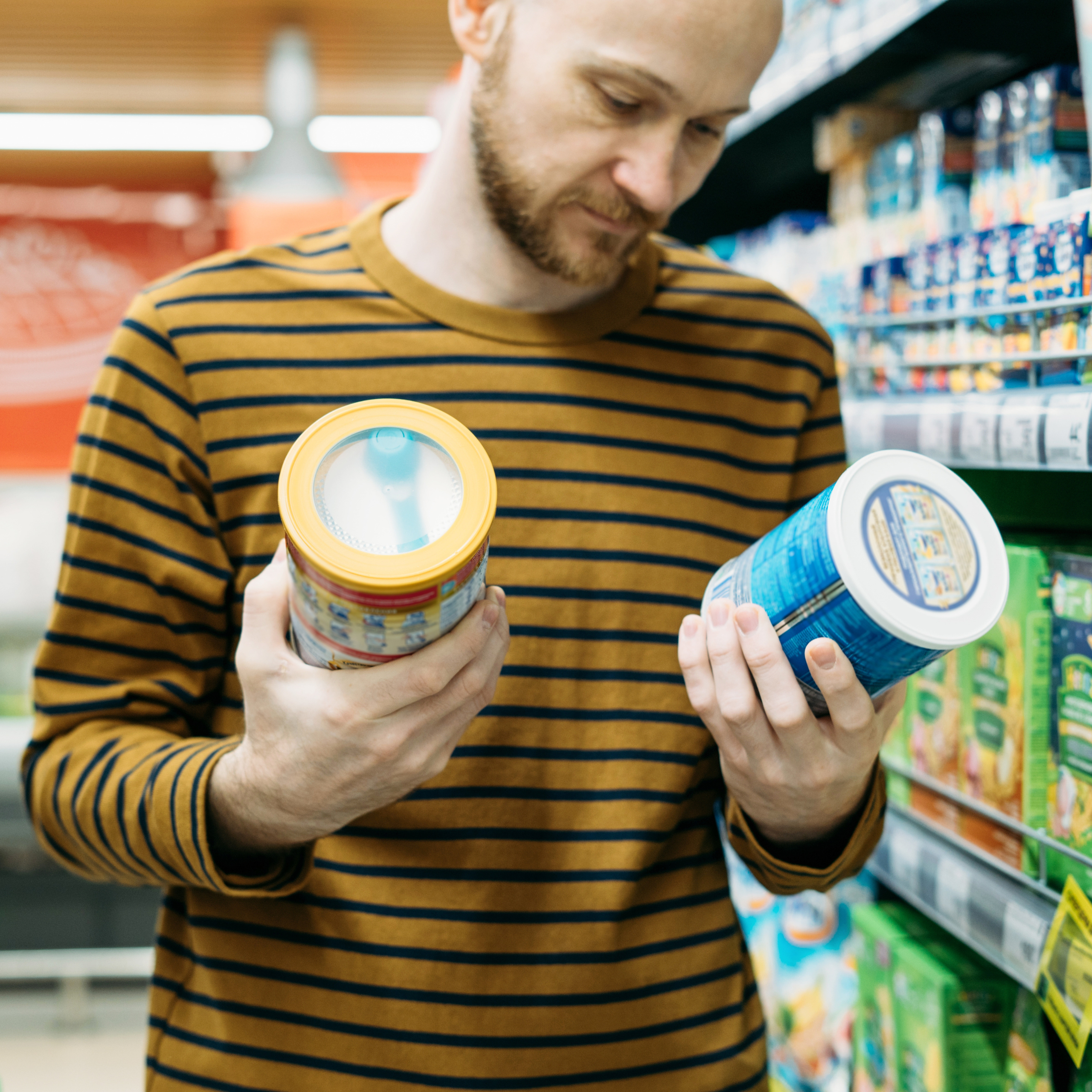 man checking nutrition labels in grocery store