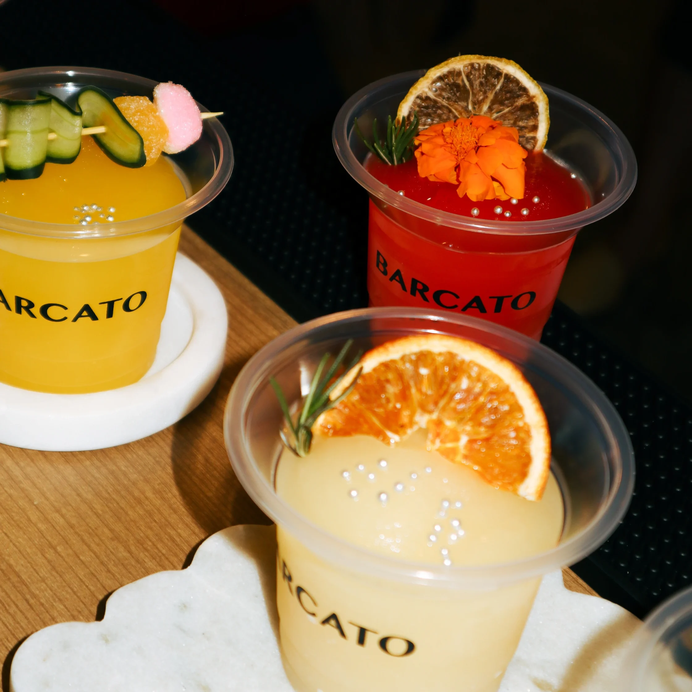 White, yellow, and red cocktails with dried fruit and candy garnish