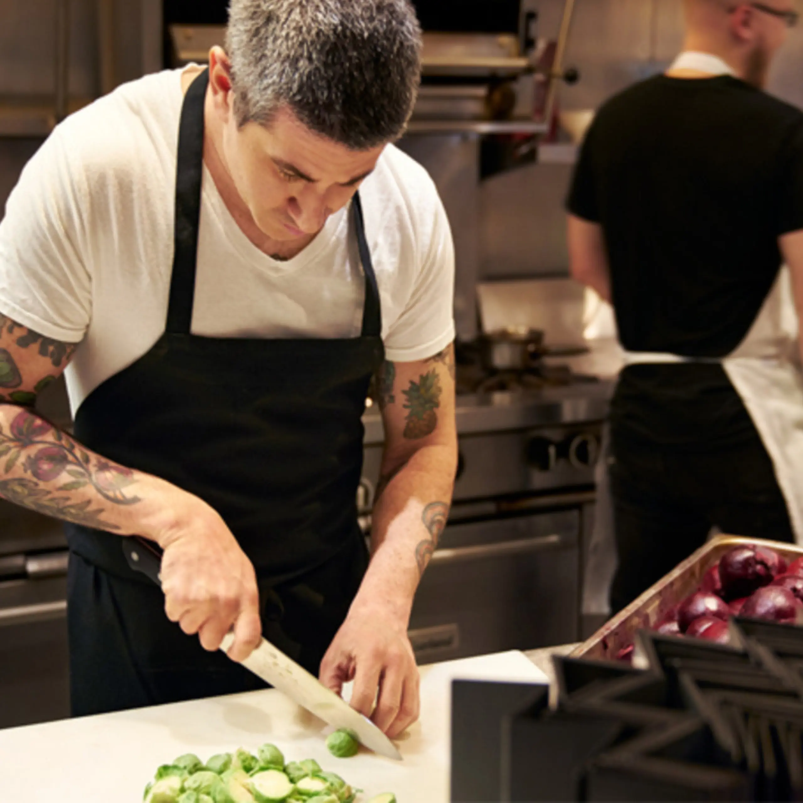 chef in an apron chopping greens