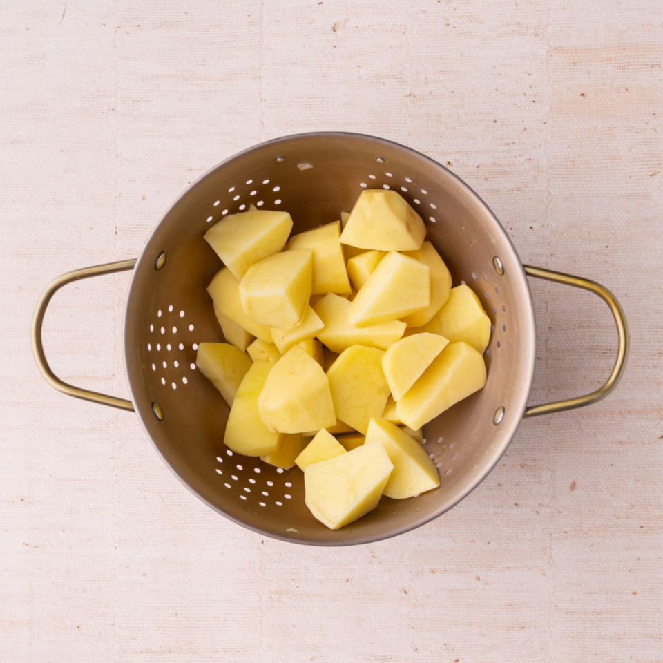 Cut potatoes in a beige colander
