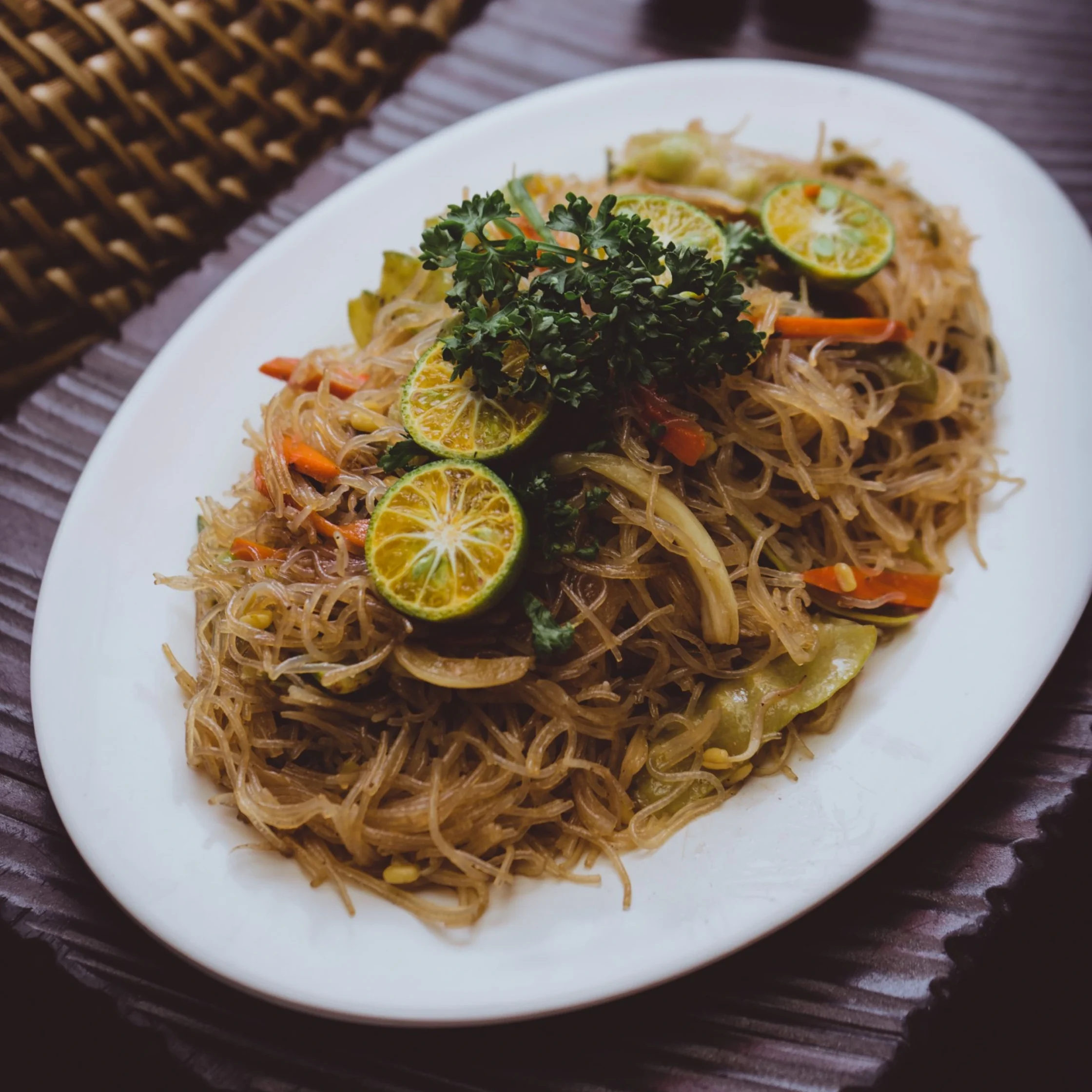 filipino style noodles with carrots and meat and calamansi slices