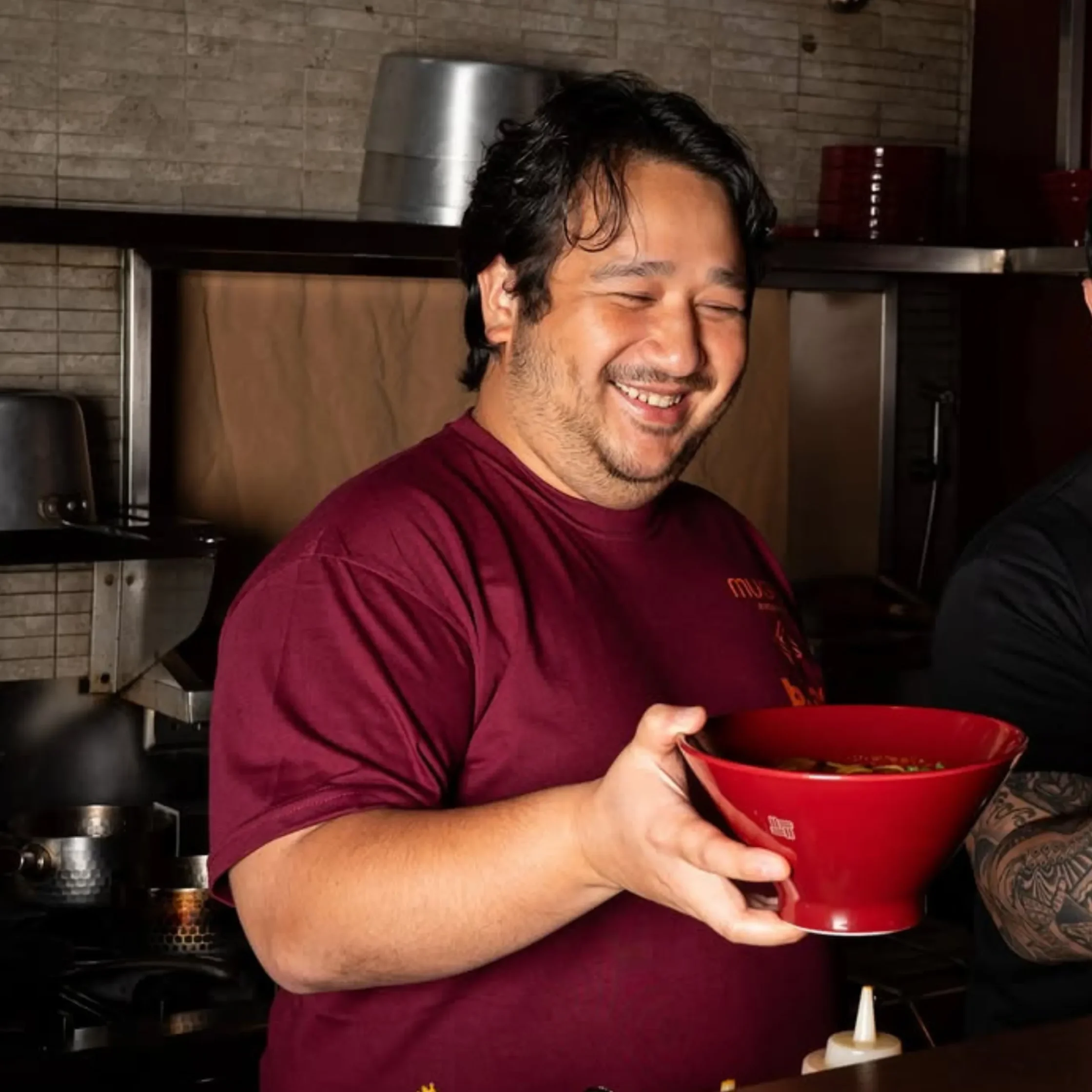 Smiling man in red shirt holding redbowl