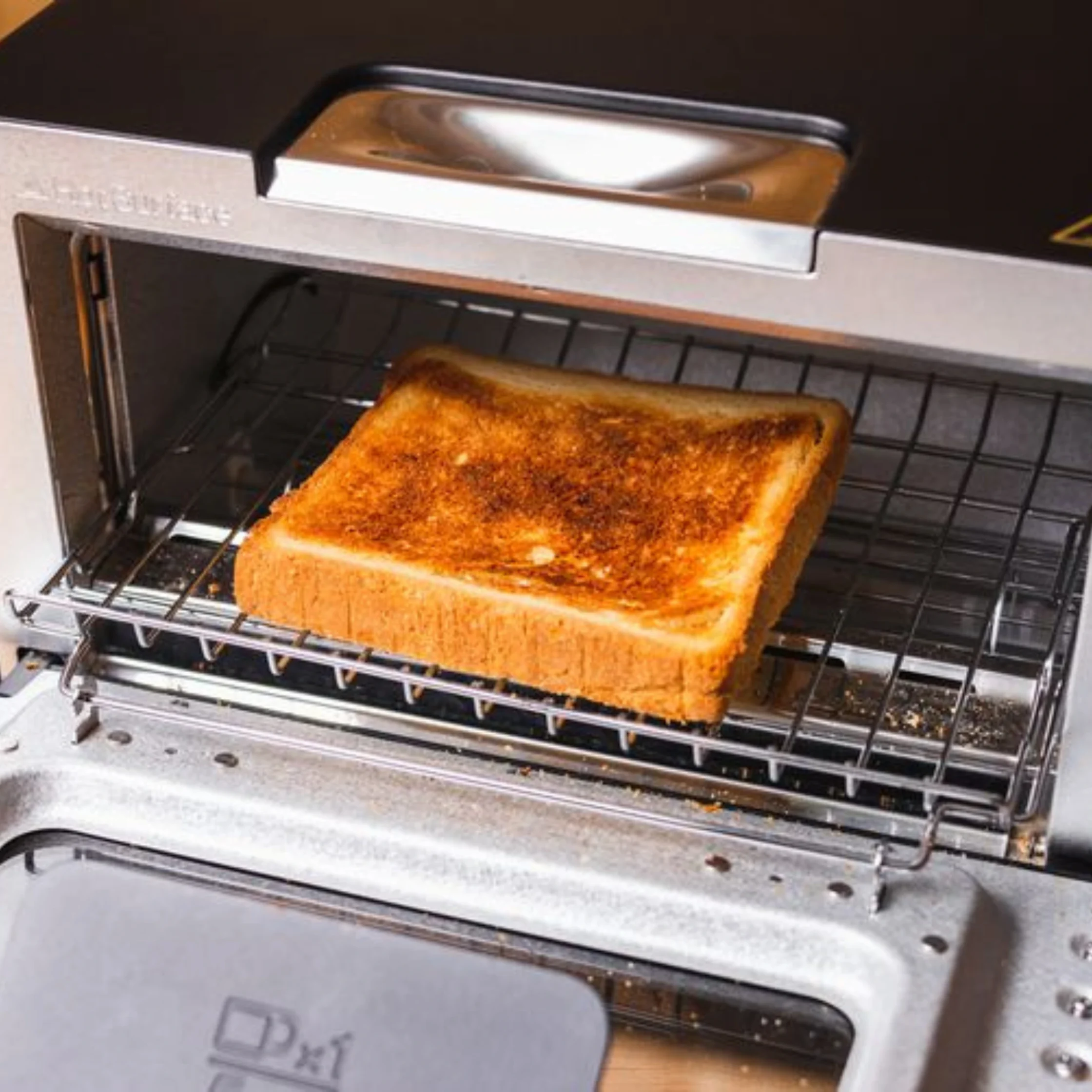 Golden brown piece of loaf coming out of toaster