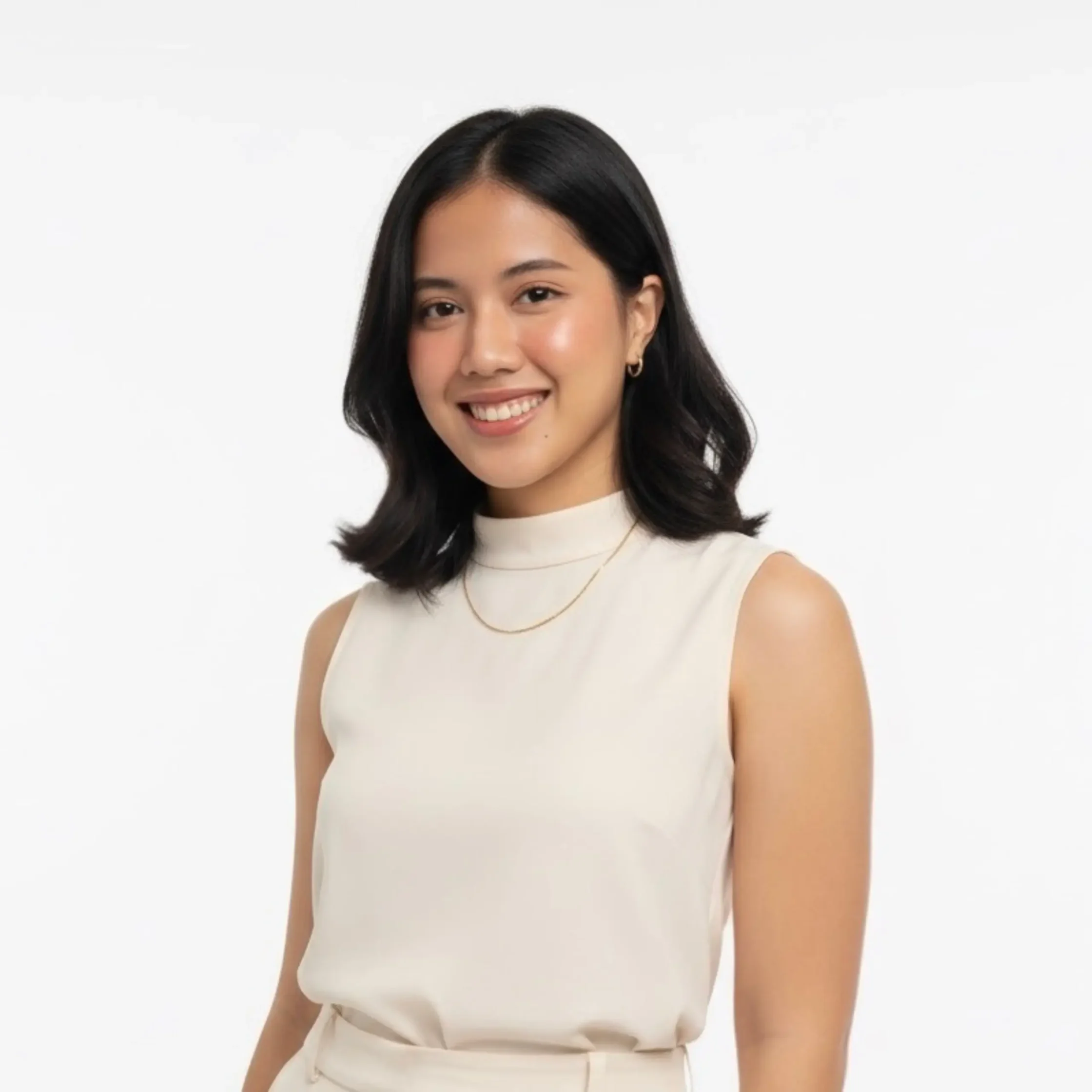 Smiling young woman with shoulder-length black hair wearing a cream sleeveless top against a white background.