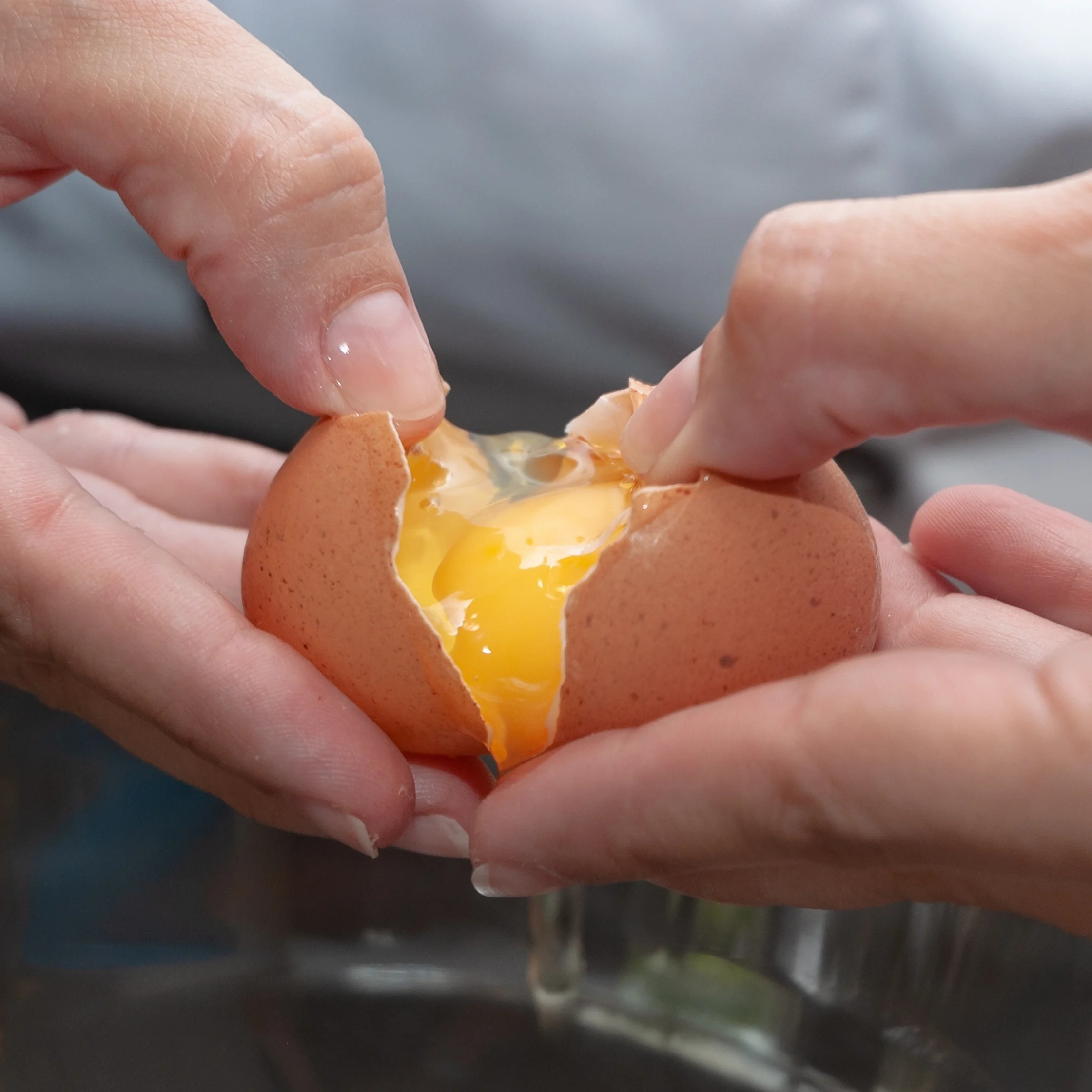 hands cracking an egg