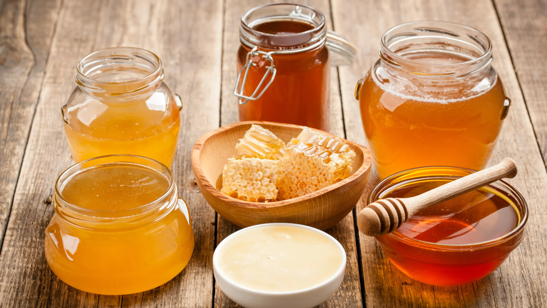 honey jars different colors with combs in the middle
