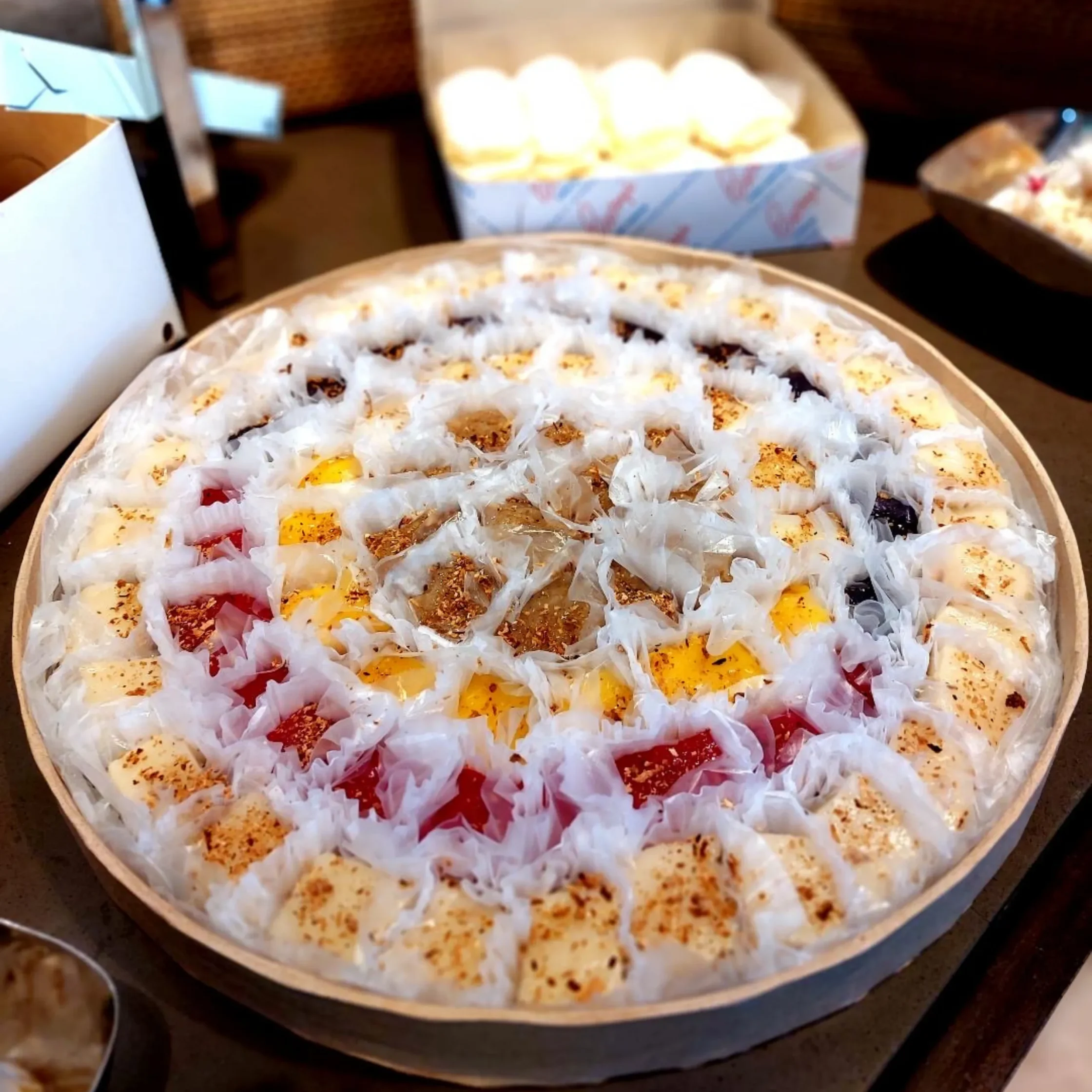 Round serving tray filled with small bite-sized pizzas in paper liners.