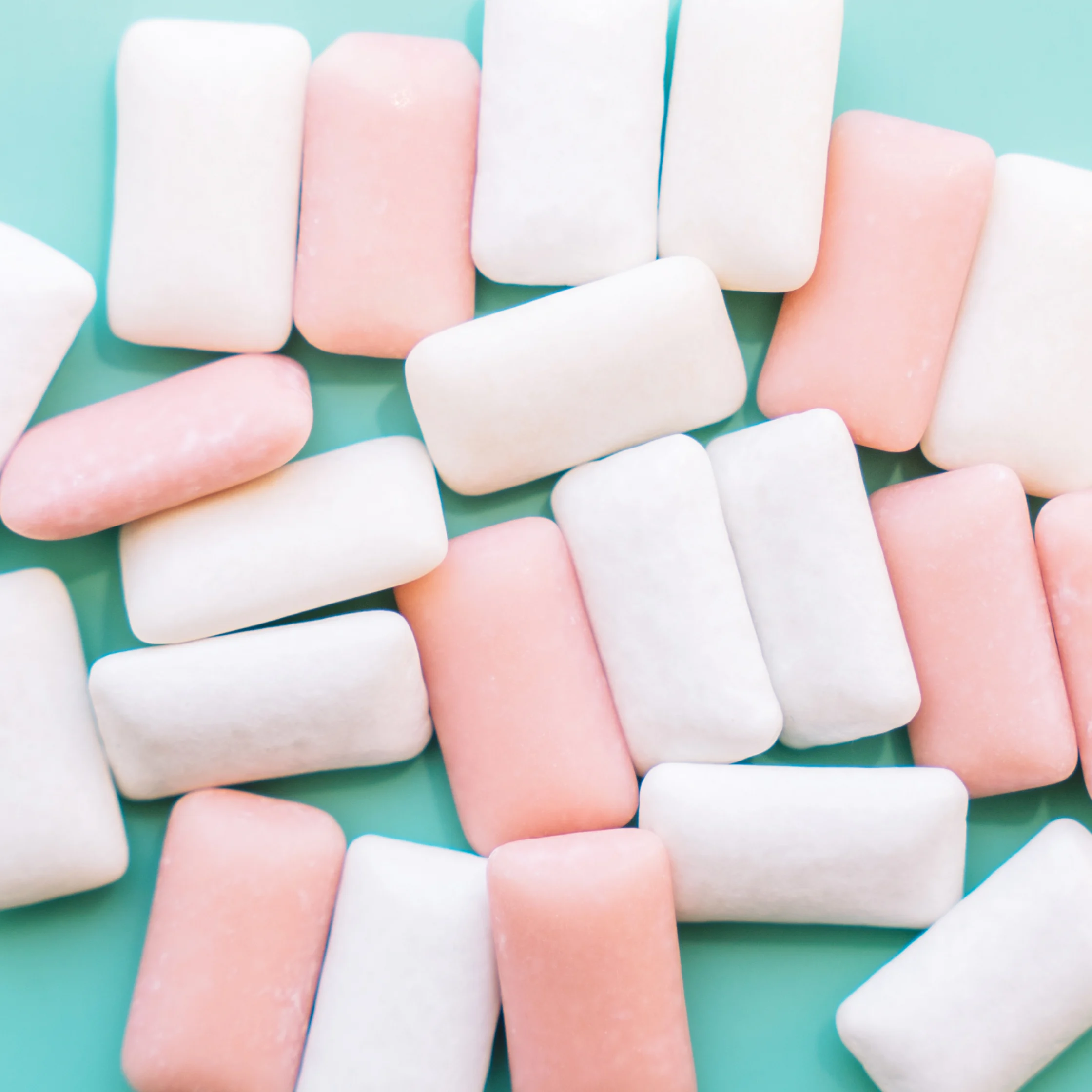 white and pink pieces of chewing gum with a cyan background