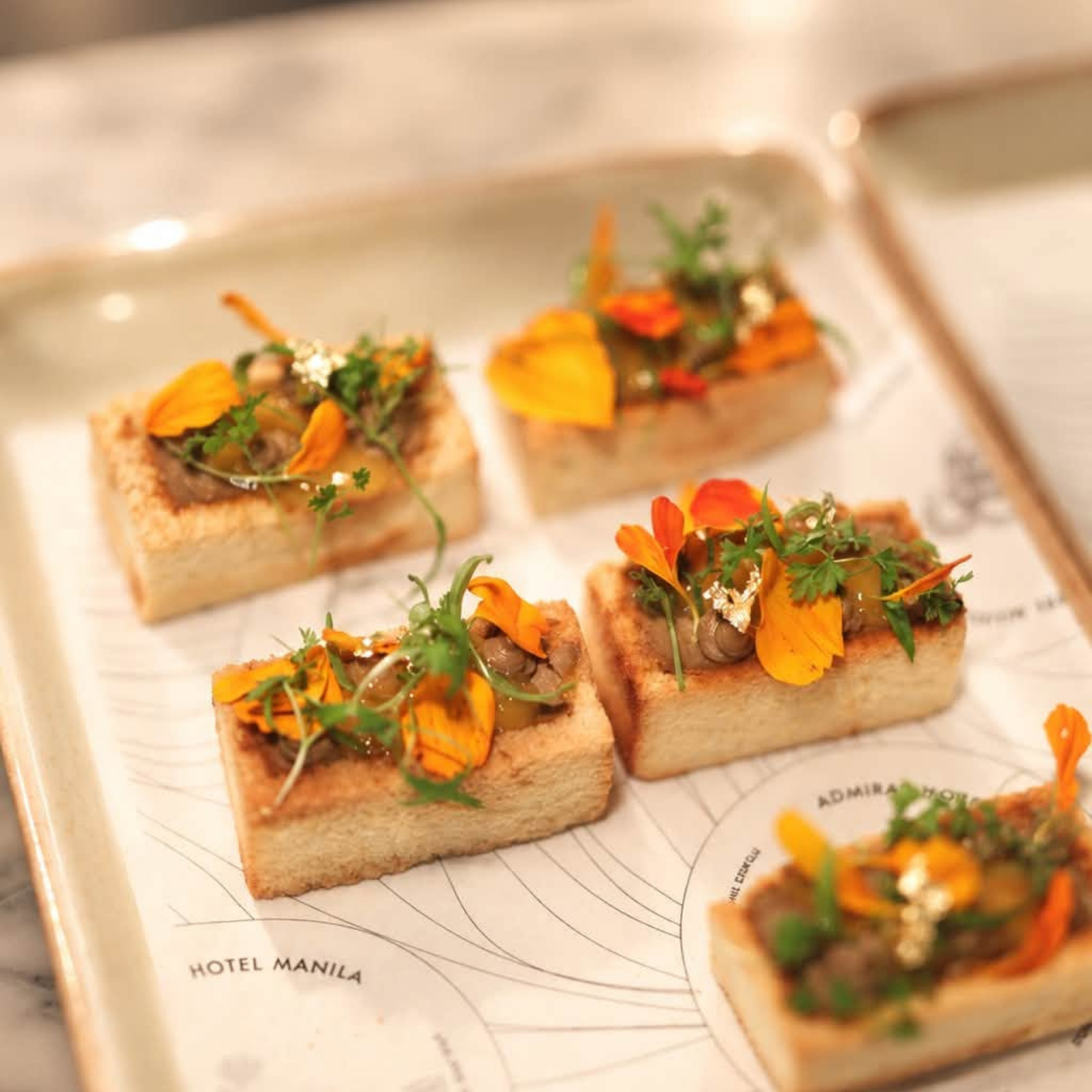 Pate on toast with floral and green garnish