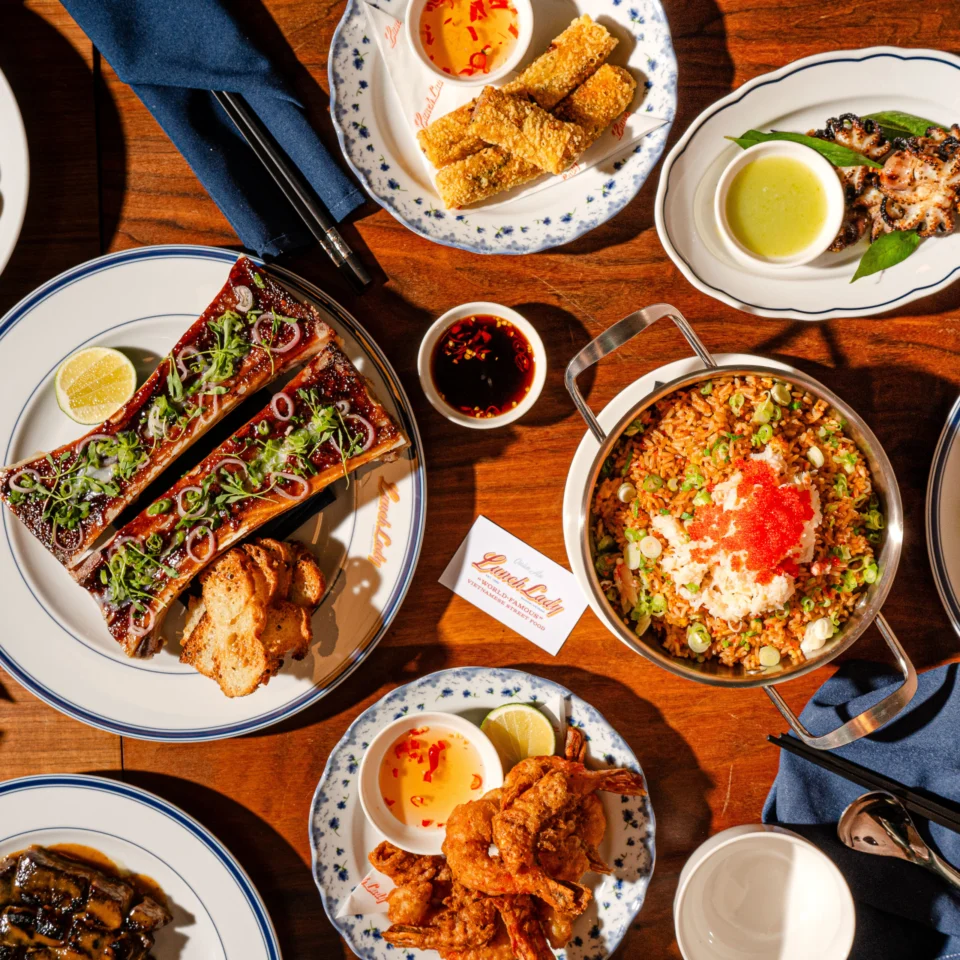 Overhead spread of Filipino food on a wooden table: grilled fish, crispy chicken, rice, seafood, sauces, and citrus, warmly inviting and celebratory.