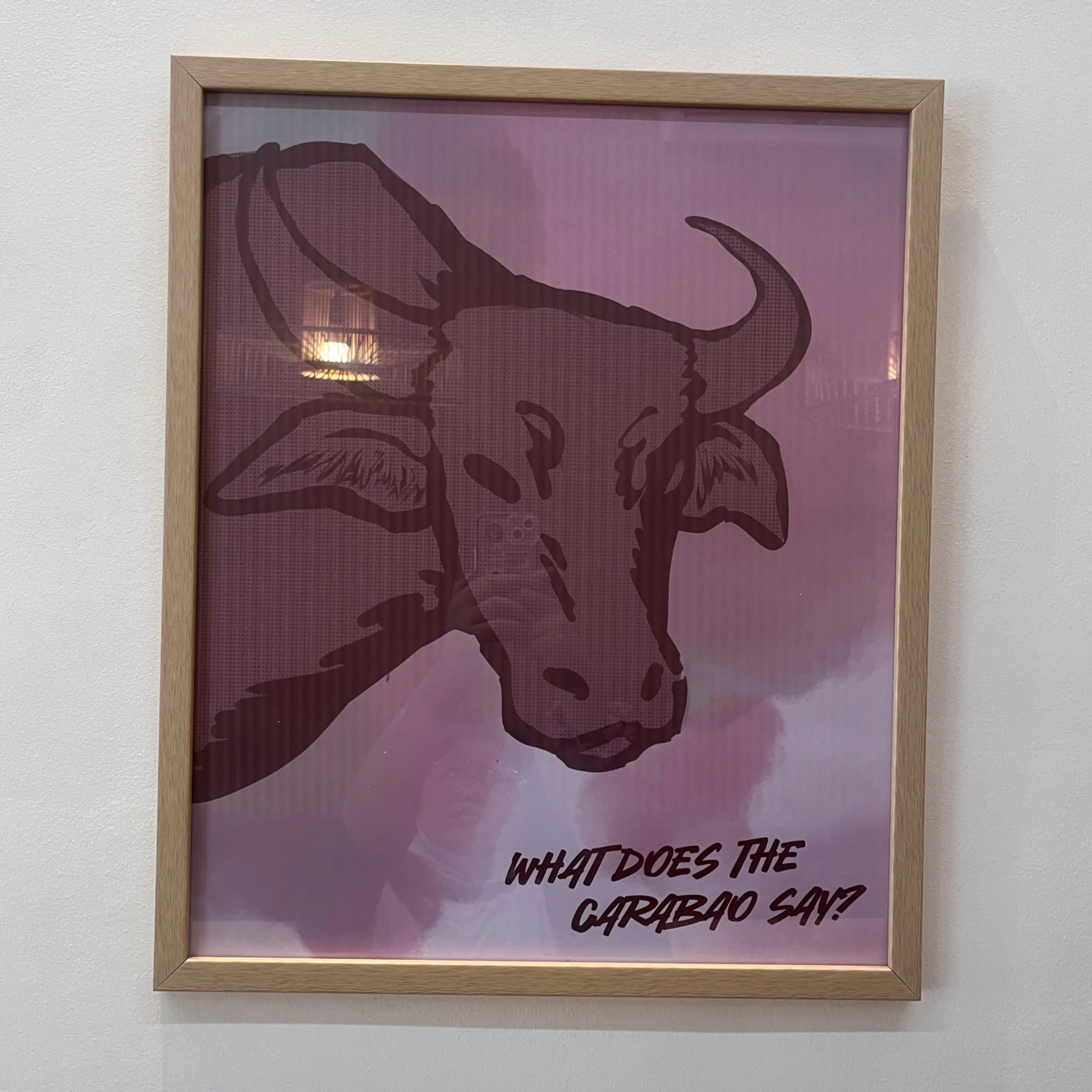 Framed purple poster featuring a bold, stylized carabao head and the words “What does the carabao say?”; playful, quirky wall art.