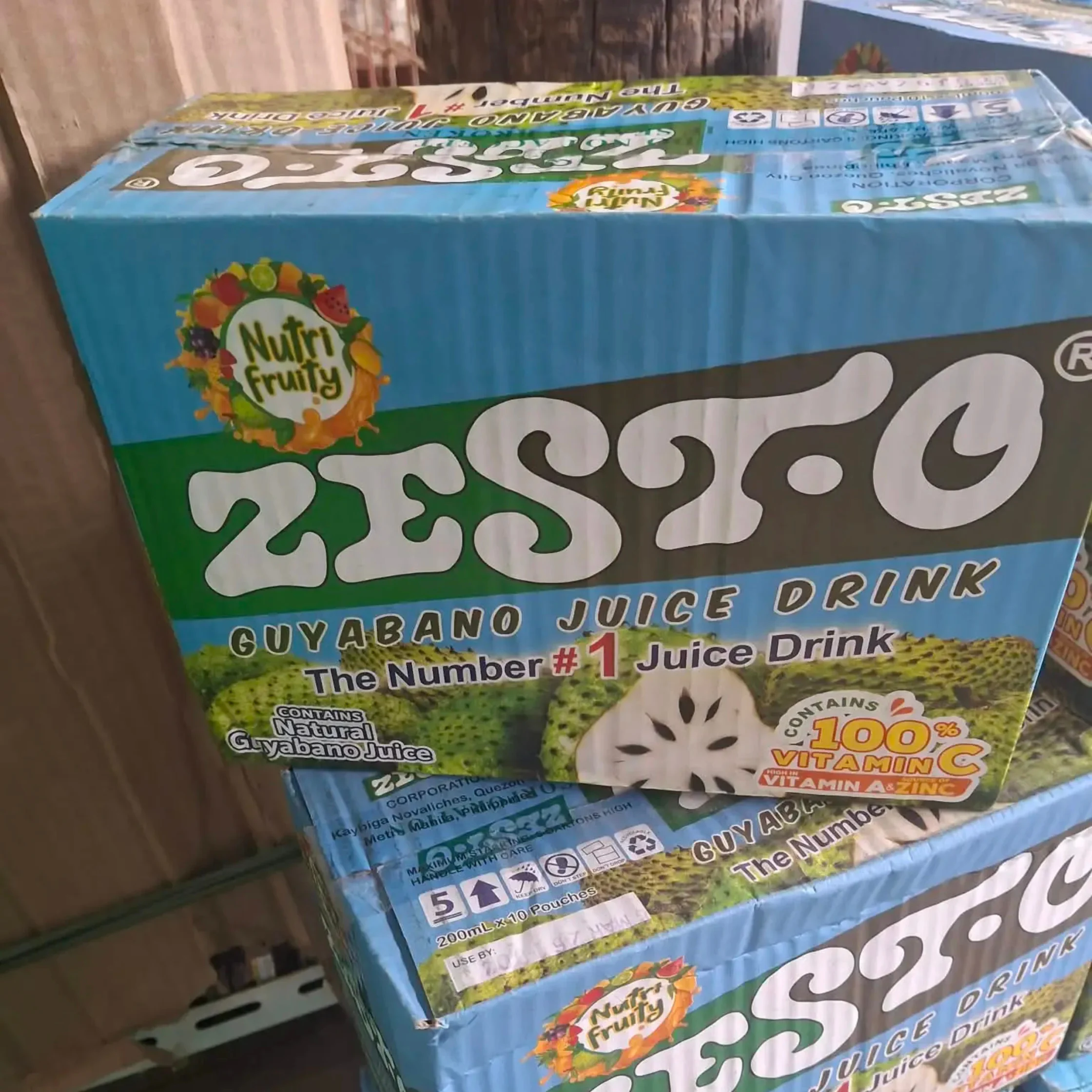 Blue Nutri Fruity Zesto guayabano juice drink carton with large white branding, fruit imagery, and “100% Vitamin C” text; the bold packaging looks bright and playful.